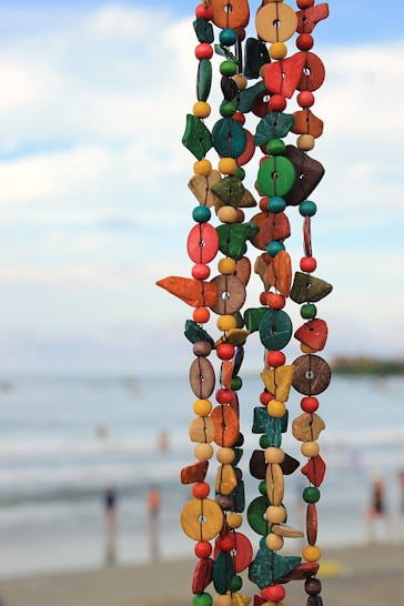 Colorful beaded garland hangs with ocean background