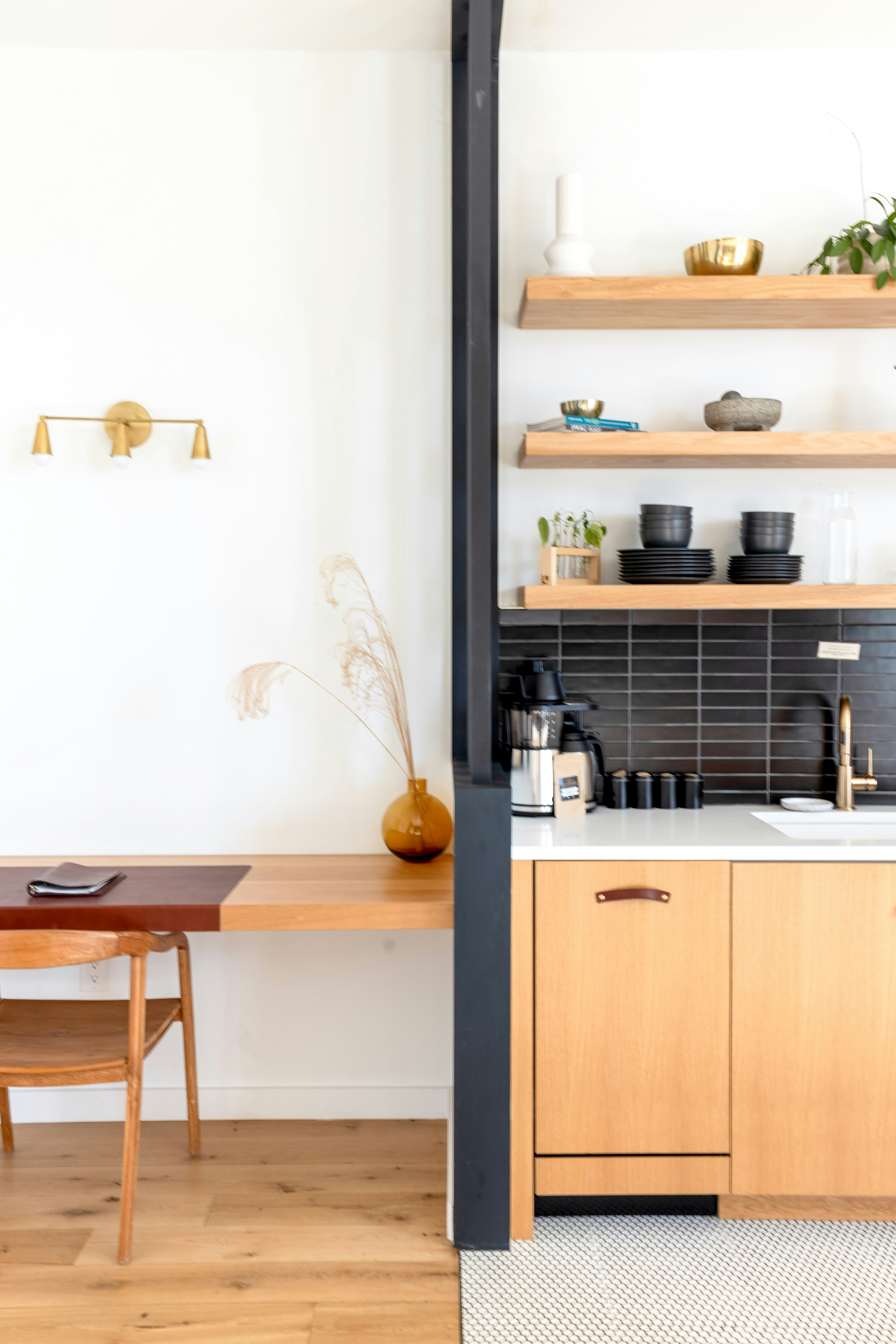 Cozinha moderna e área de escrivaninha com detalhes em madeira.