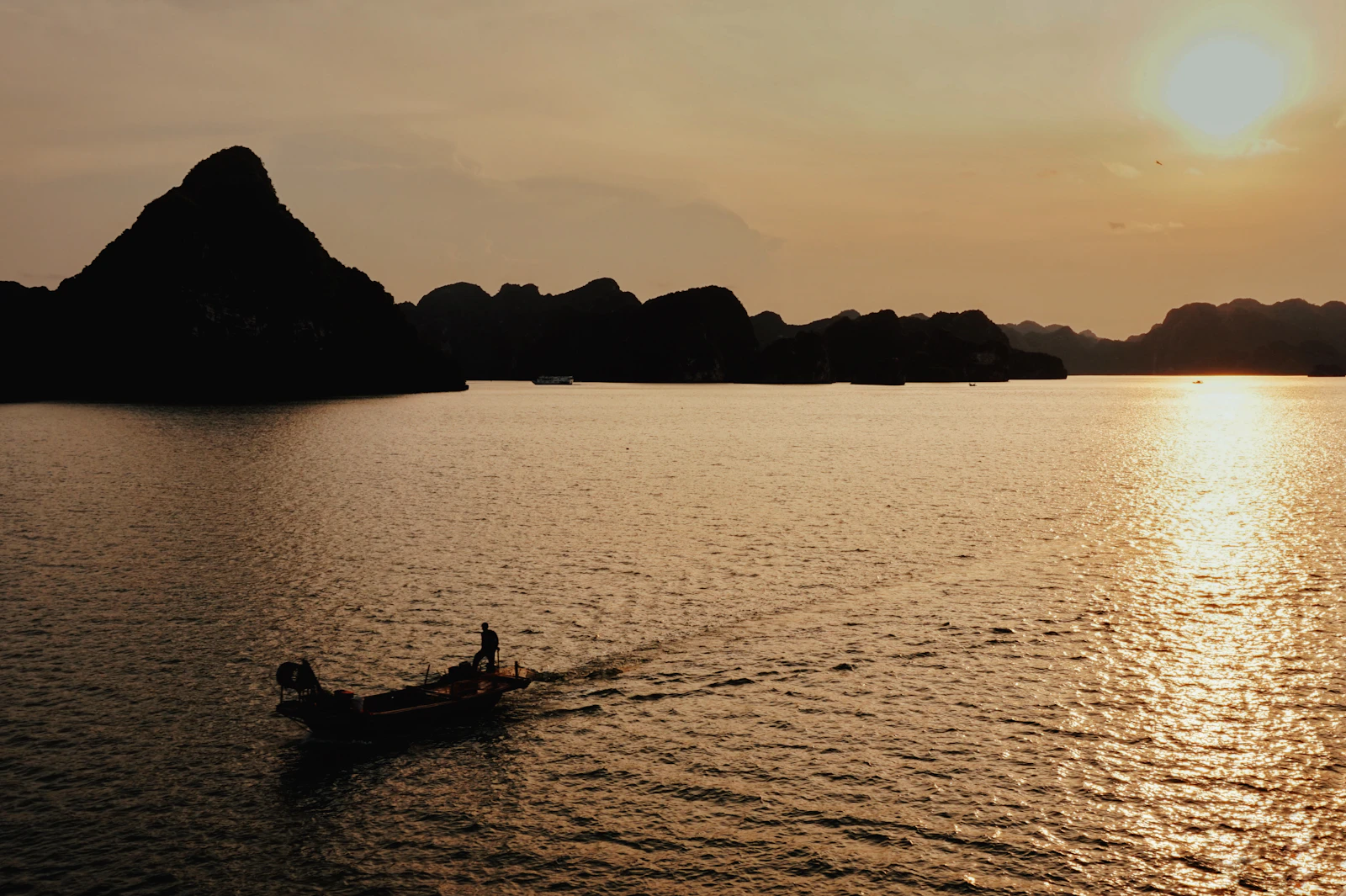 Boat sailing on Ha Long Bay at sunset in Vietnam