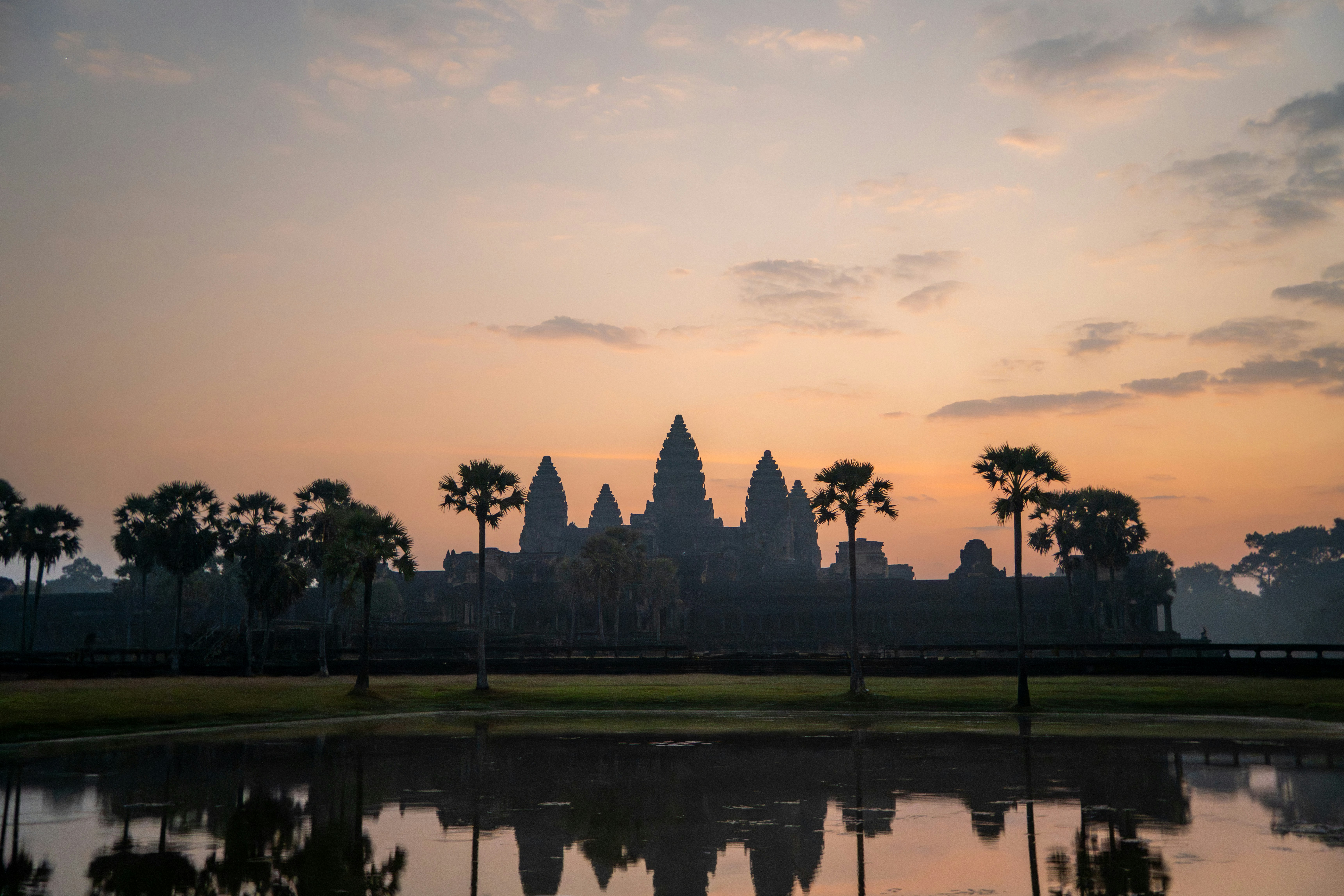 Angkor wat temple complex at sunrise with reflection.
