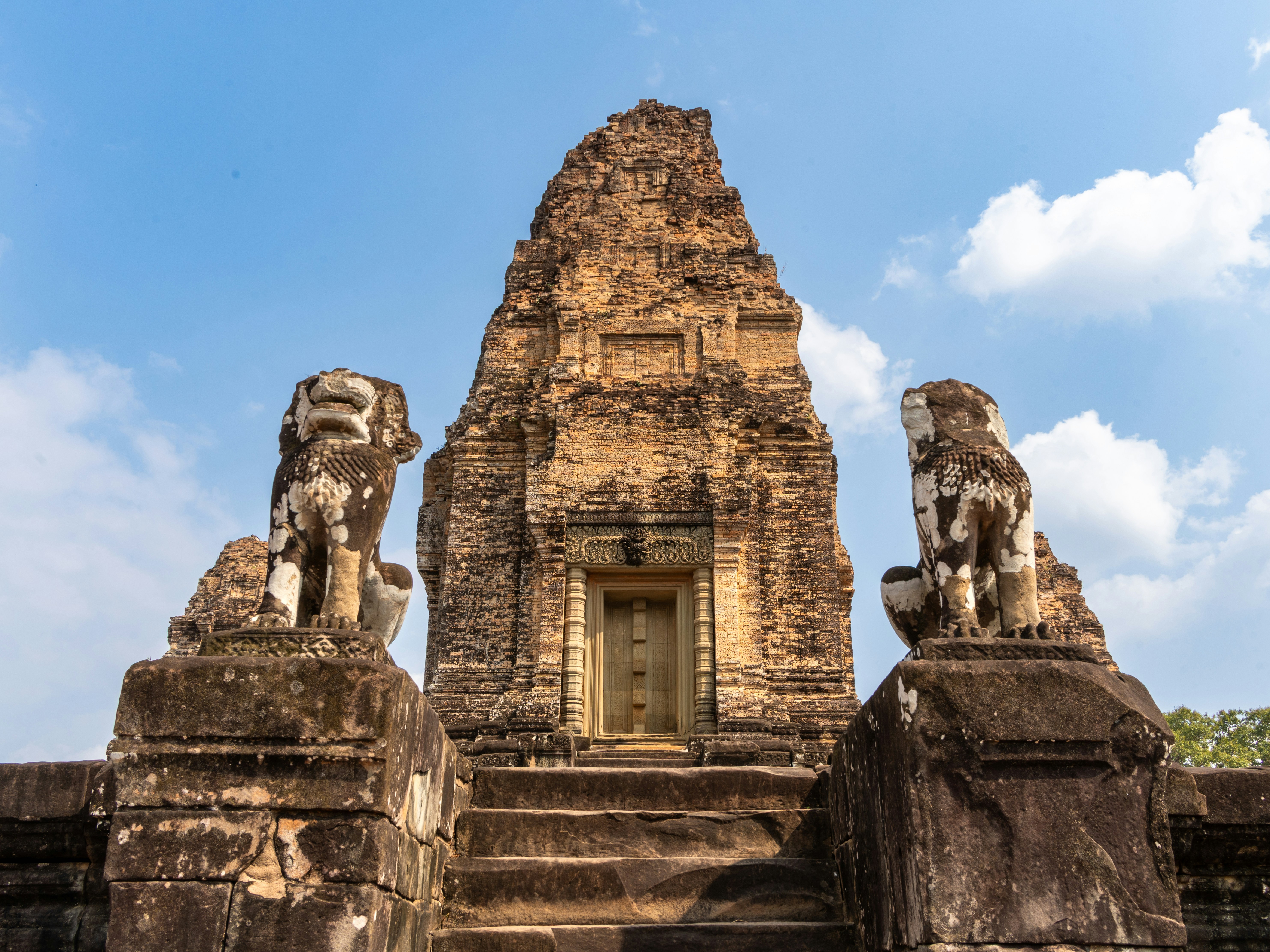 Ancient temple ruins with stone lion statues guarding entrance