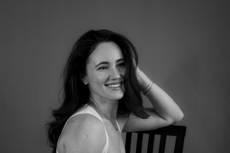 uśmiechnięta kobieta z ciemnymi włosami opiera się wygodnie