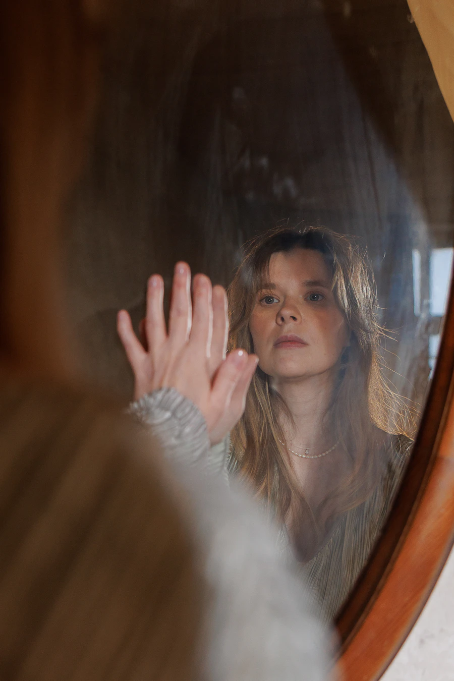 A woman looking at her own reflection in a mirror