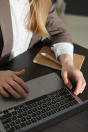 Woman working on a laptop with notebook and notebook.