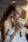 Bride smelling a bouquet of white roses