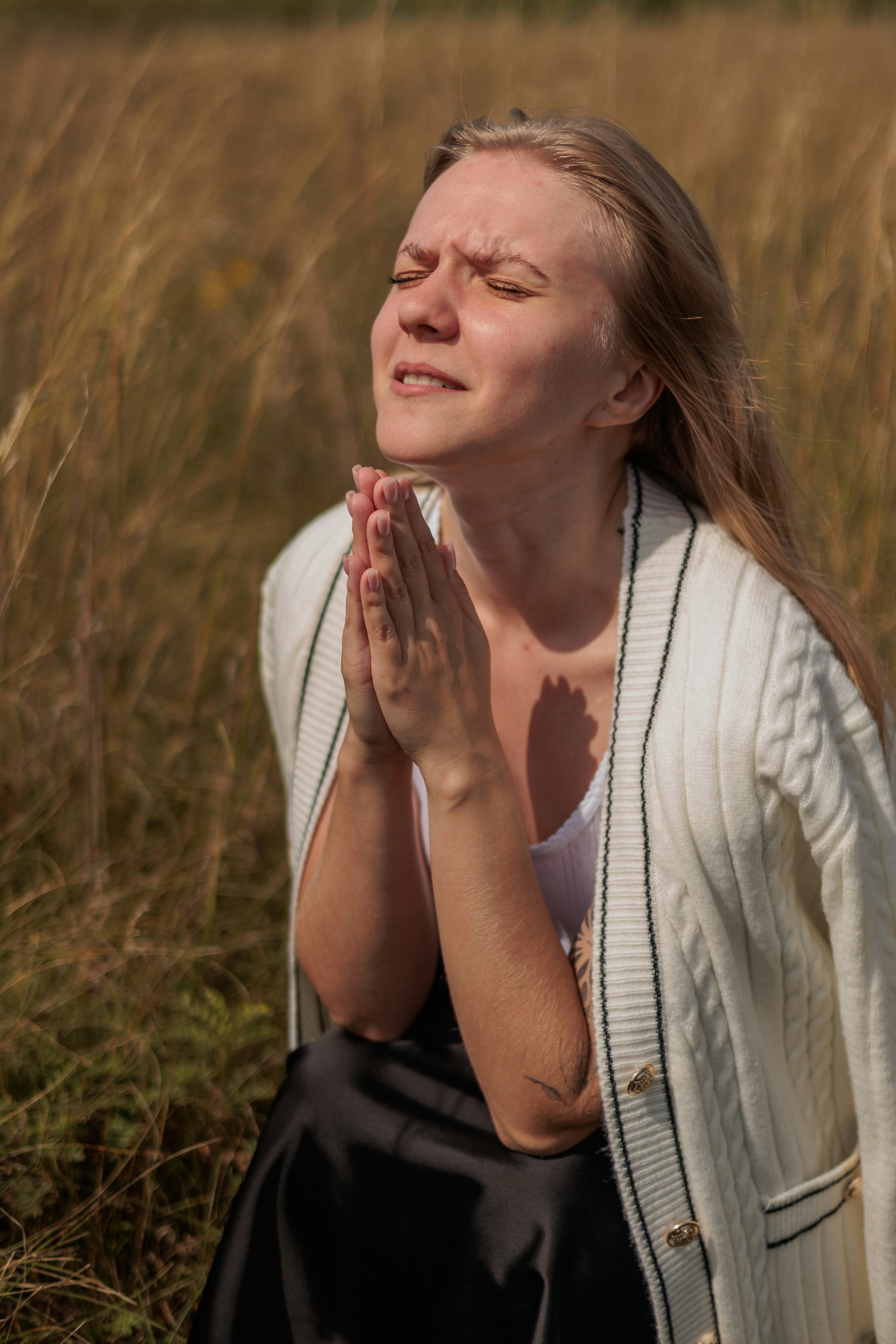 Eine Frau, die auf einem Feld betet