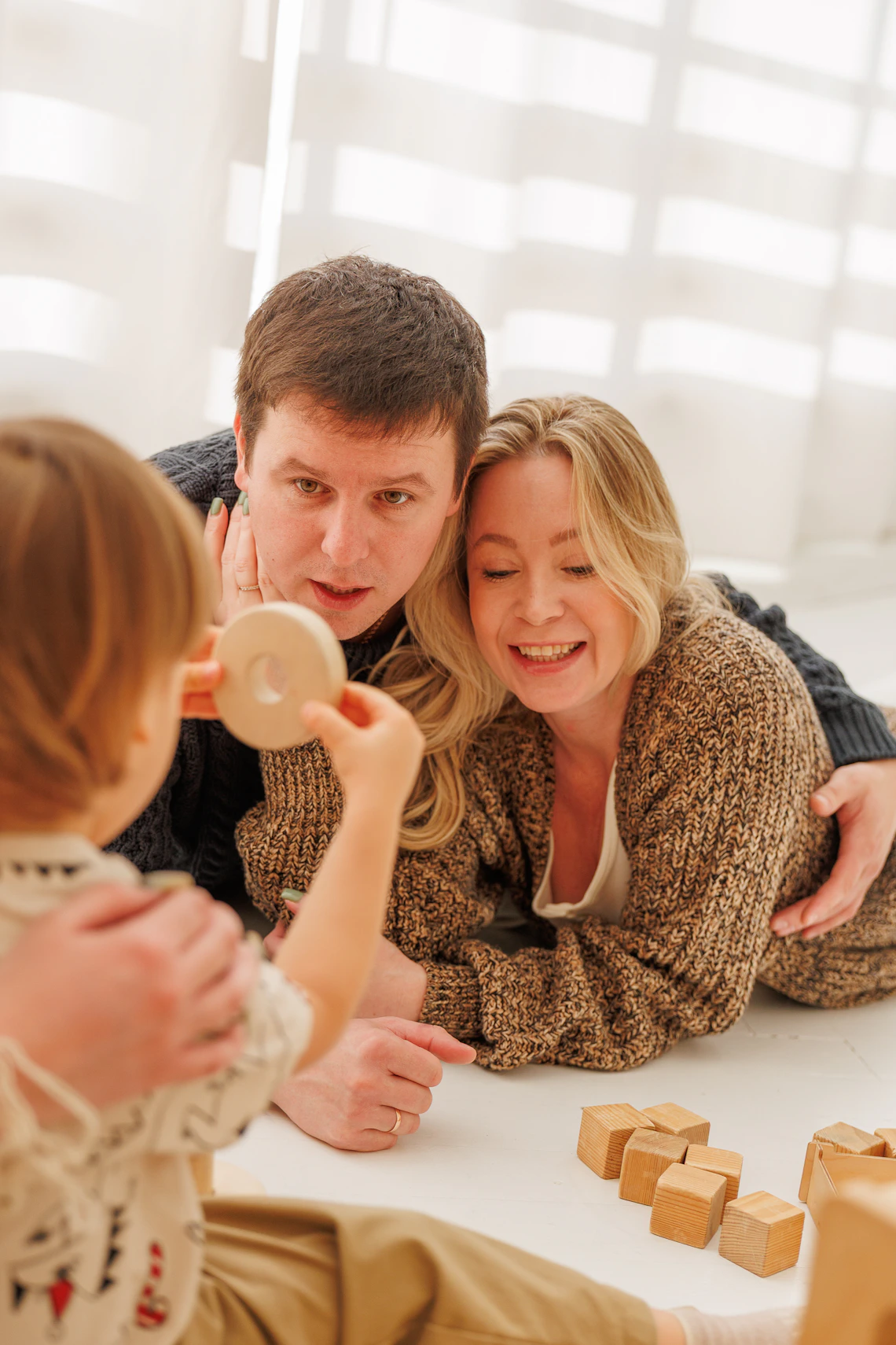 Parents observing a child during open-ended wooden block play