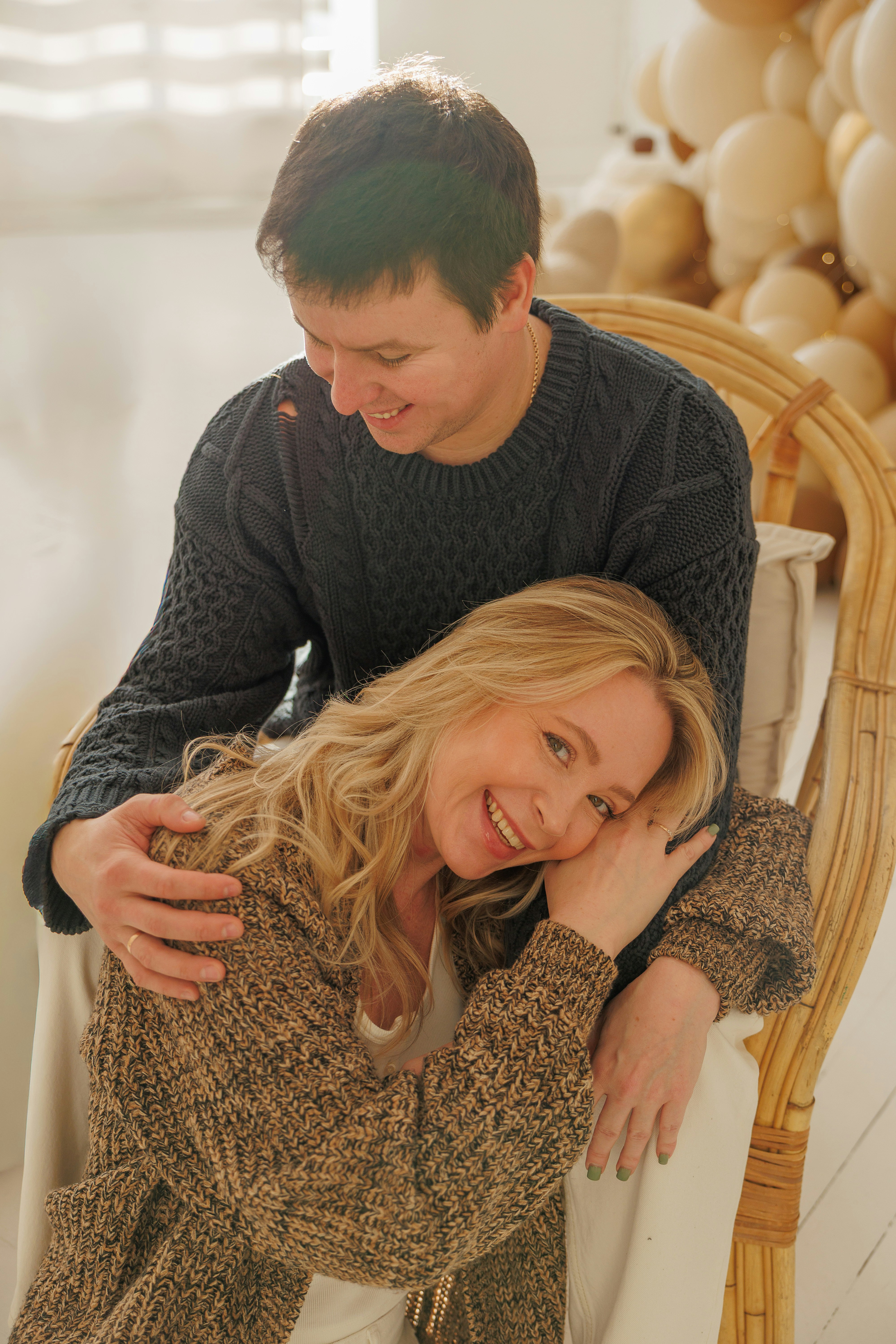 Ein Mann und eine Frau, die in einer gemütlichen Umgebung lächeln.