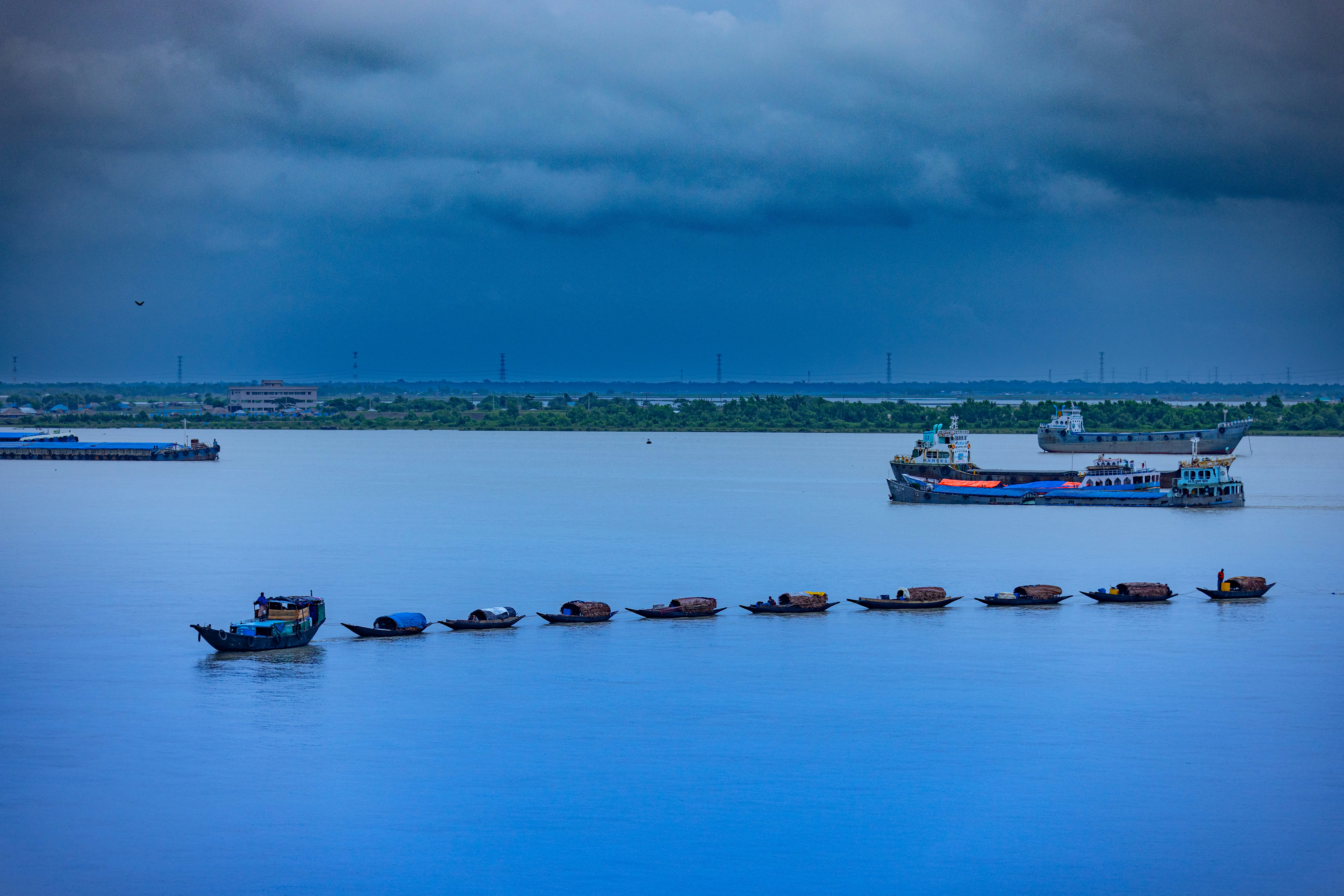 Cargo ships sailing on a wide, calm river