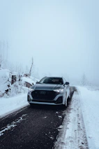 A grey audi drives on a snowy road