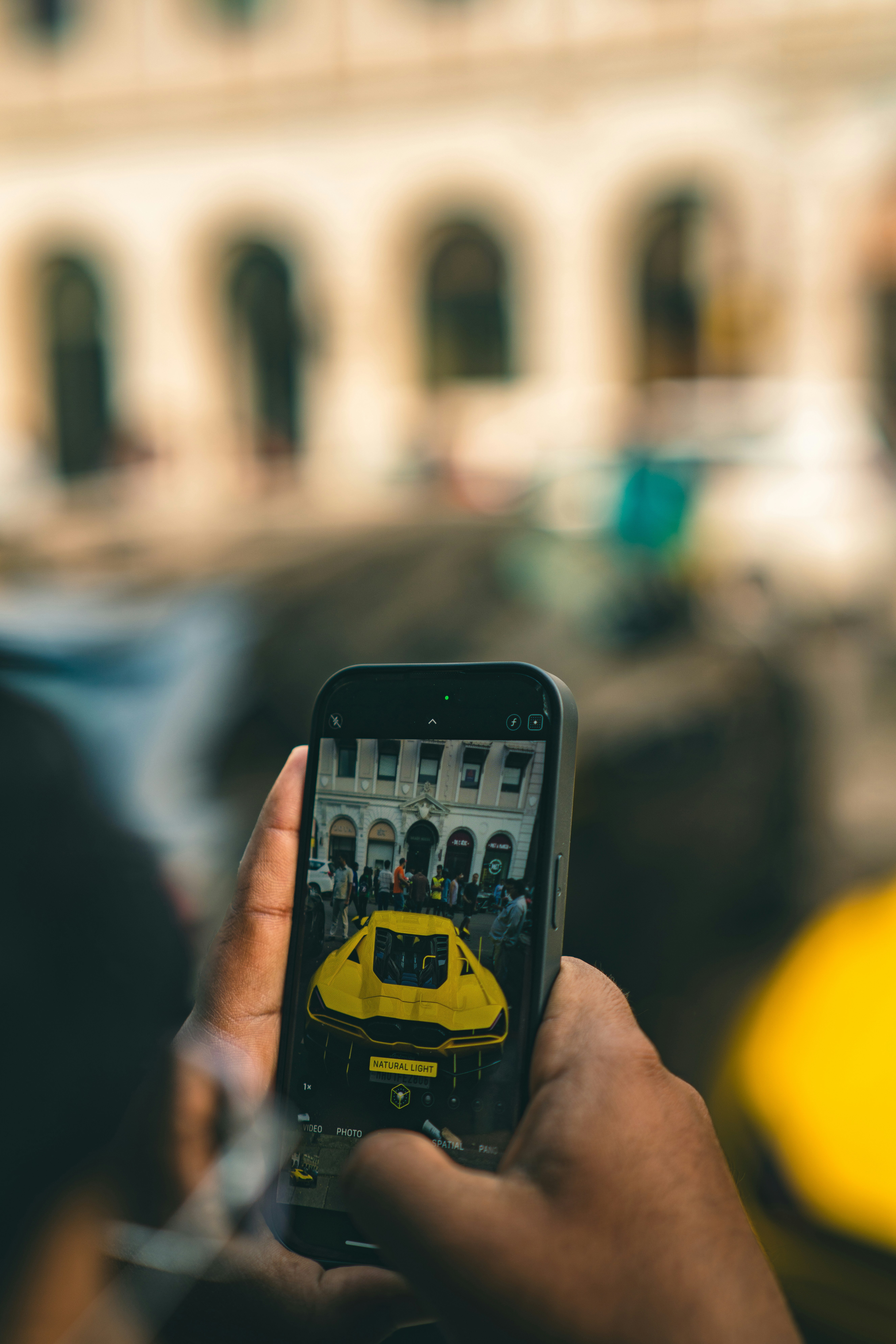 Bir otomobilin yanında araç ilanına bakan akıllı telefon kullanıcısı