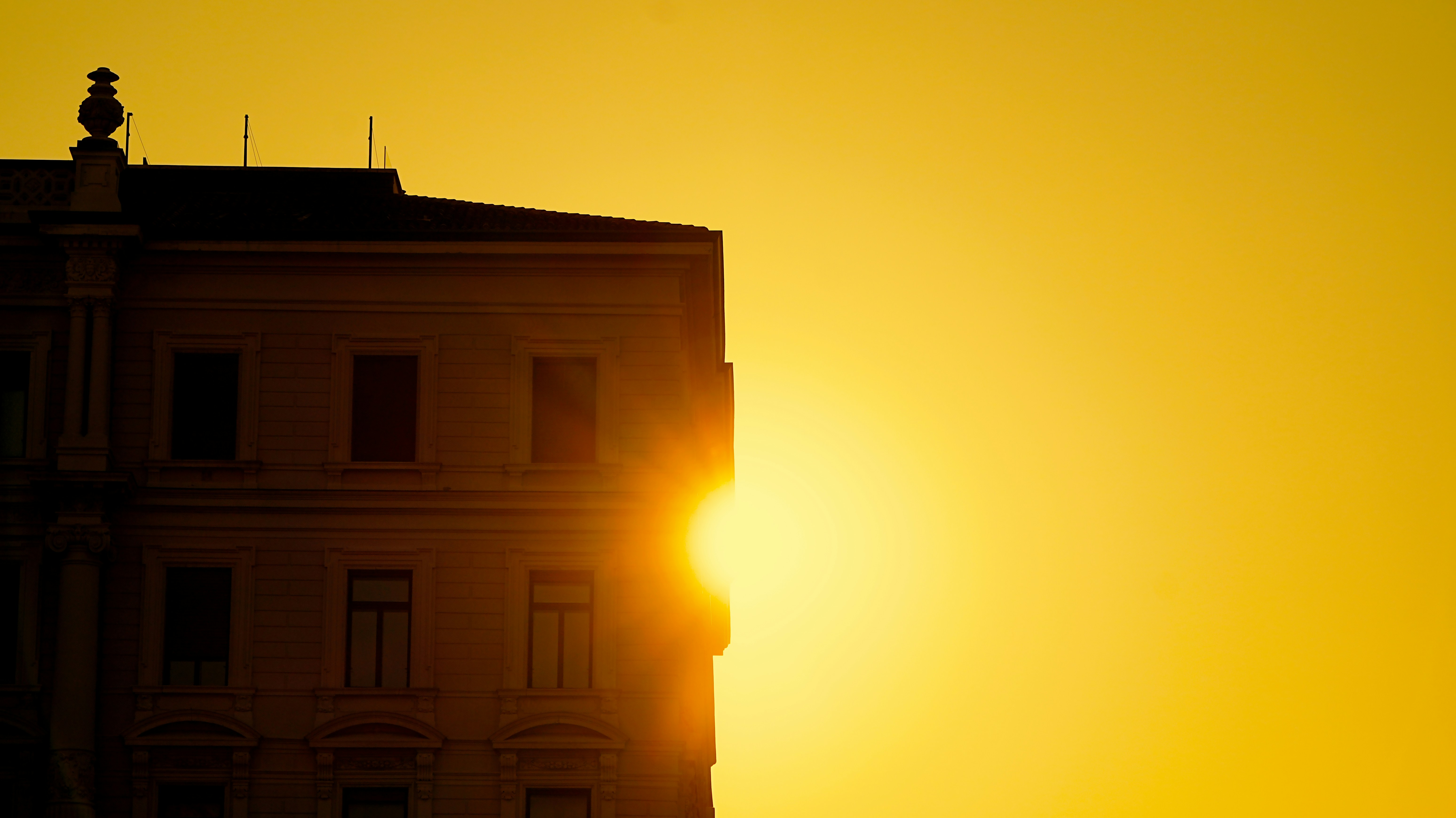 Sun setting behind a building at sunset