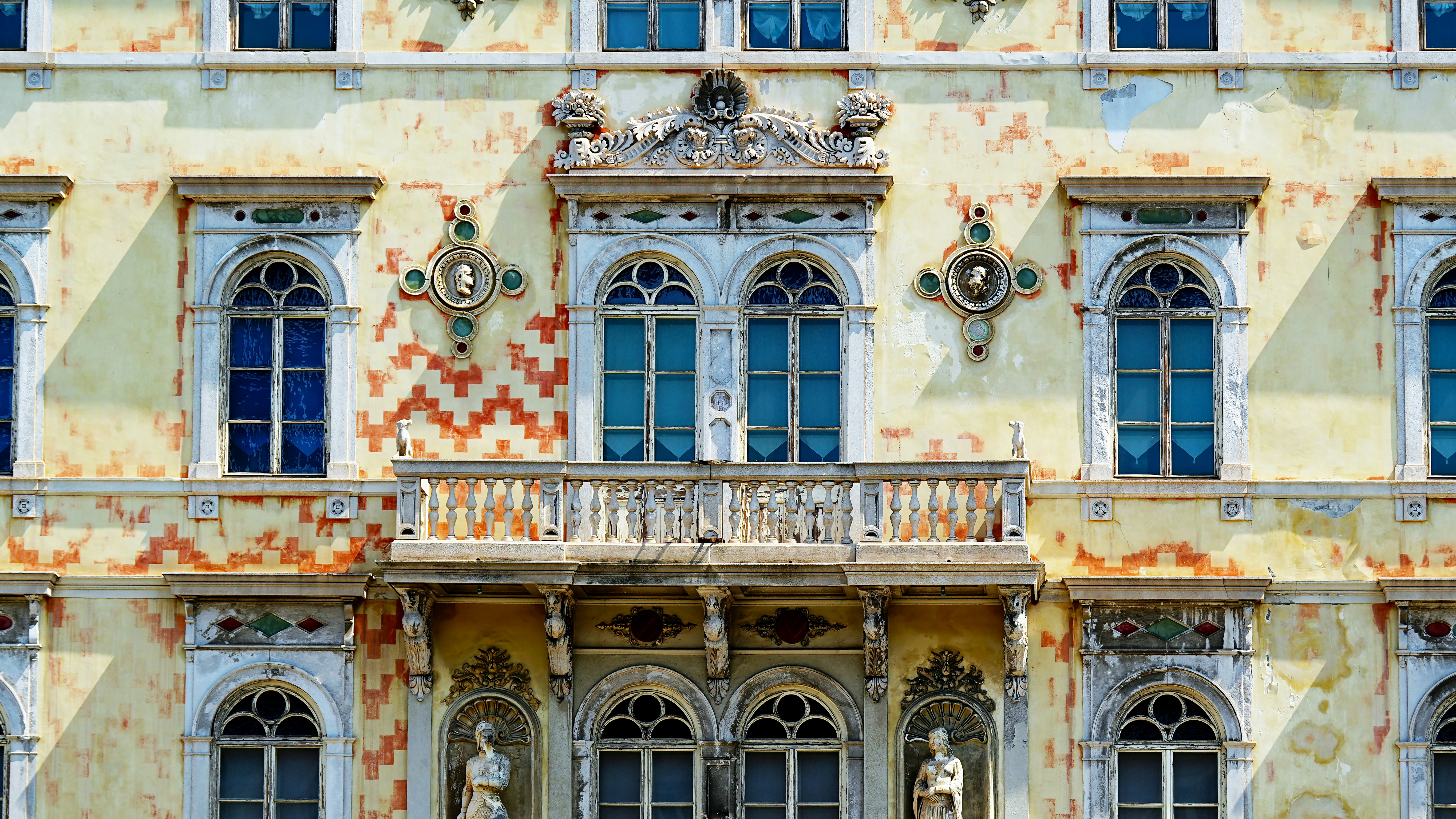 Verzierte Gebäudefassade mit Bogenfenstern und Balkon