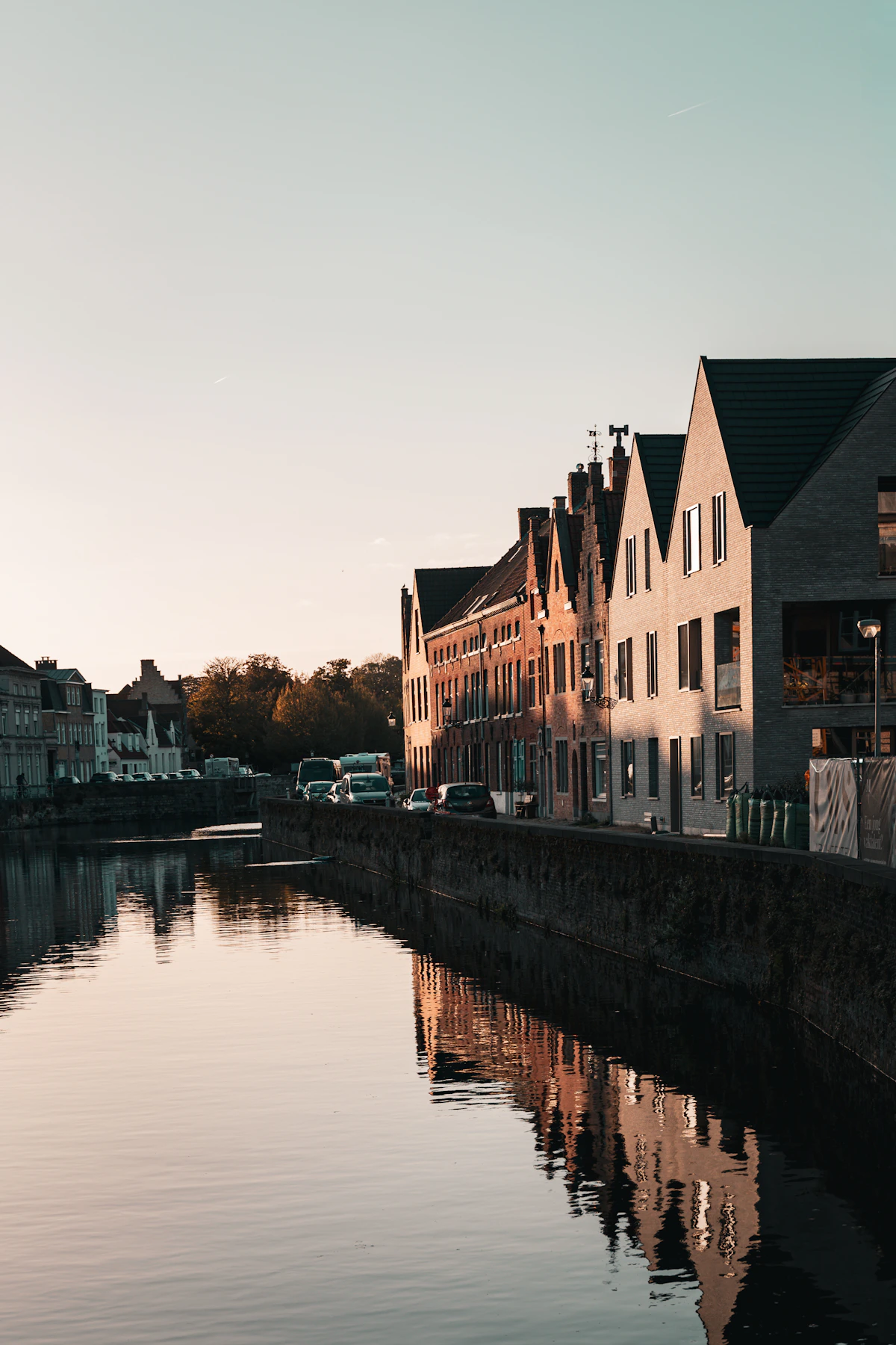 Historic buildings reflected in a calm European canal at sunset