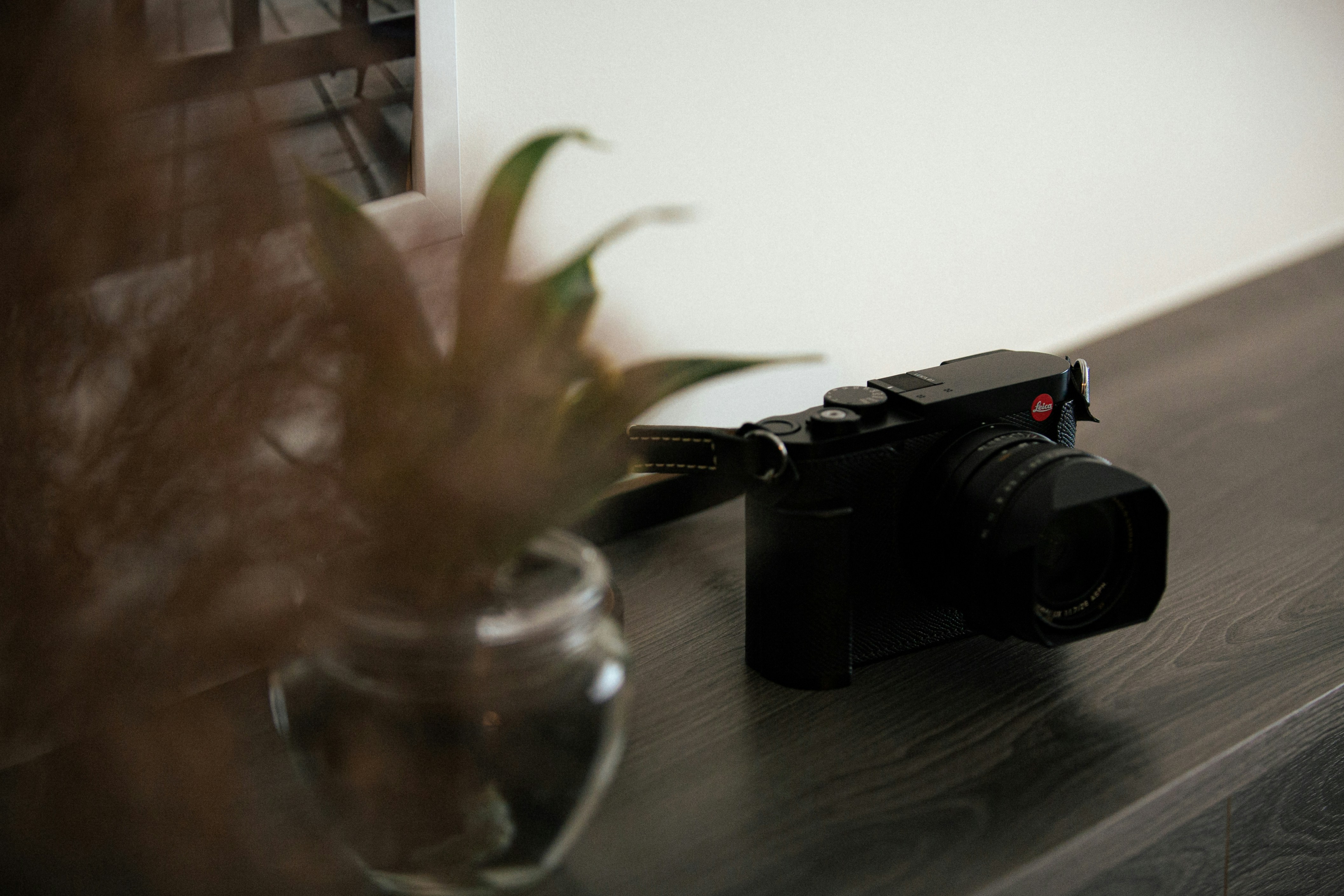 A black digital camera rests on a wooden surface.