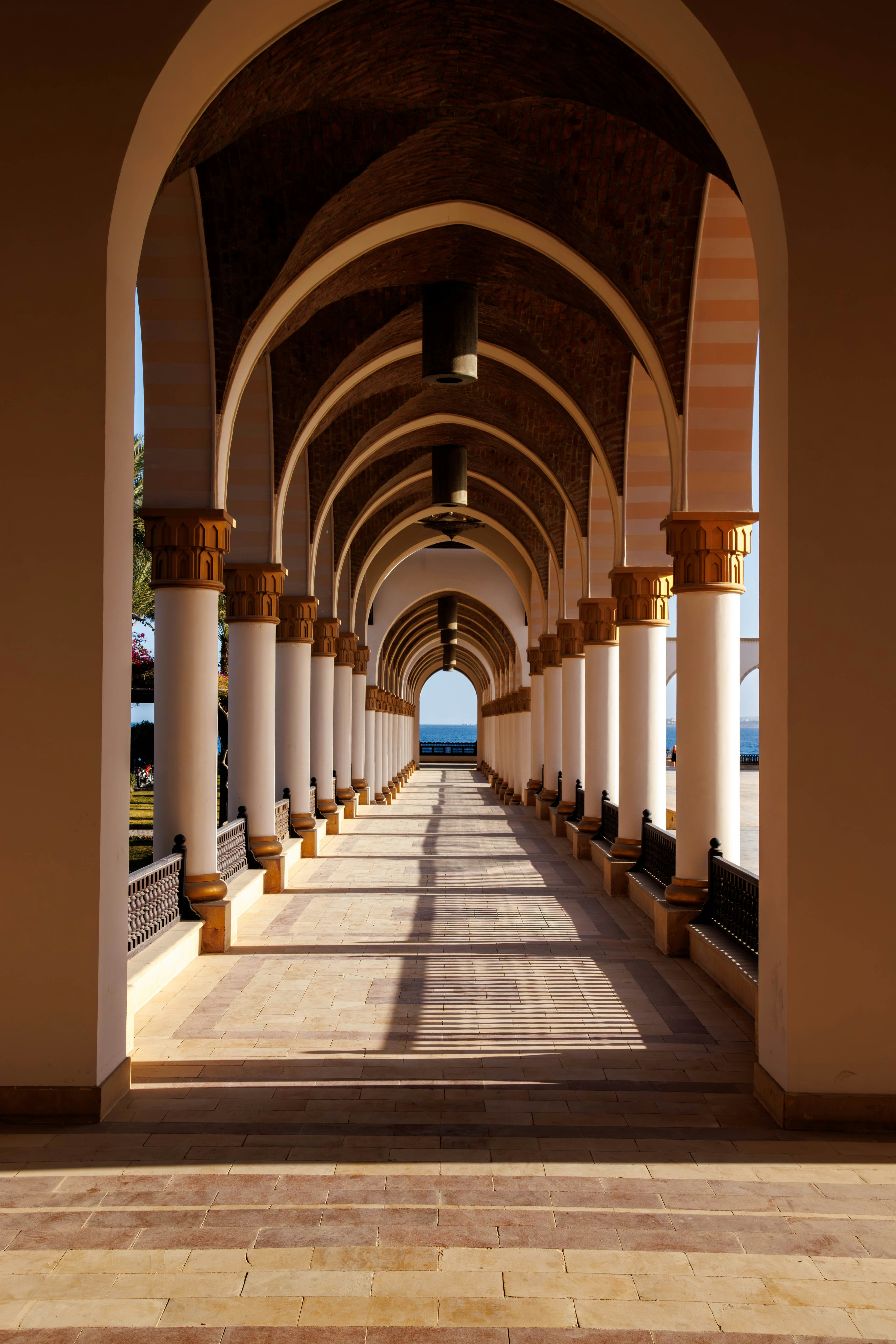 Arched walkway with columns leading to the ocean view.