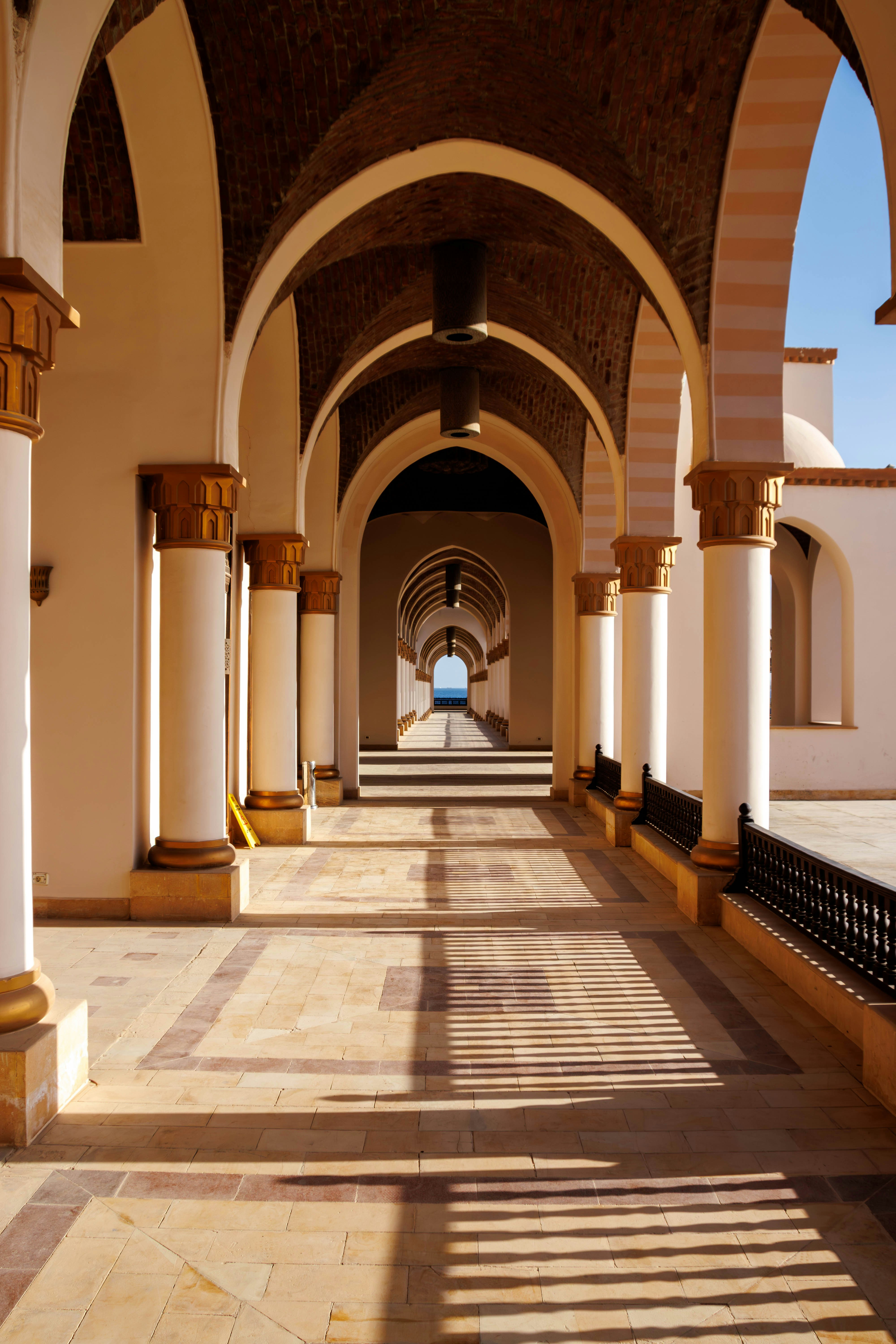 Arched walkway with columns leading to the ocean