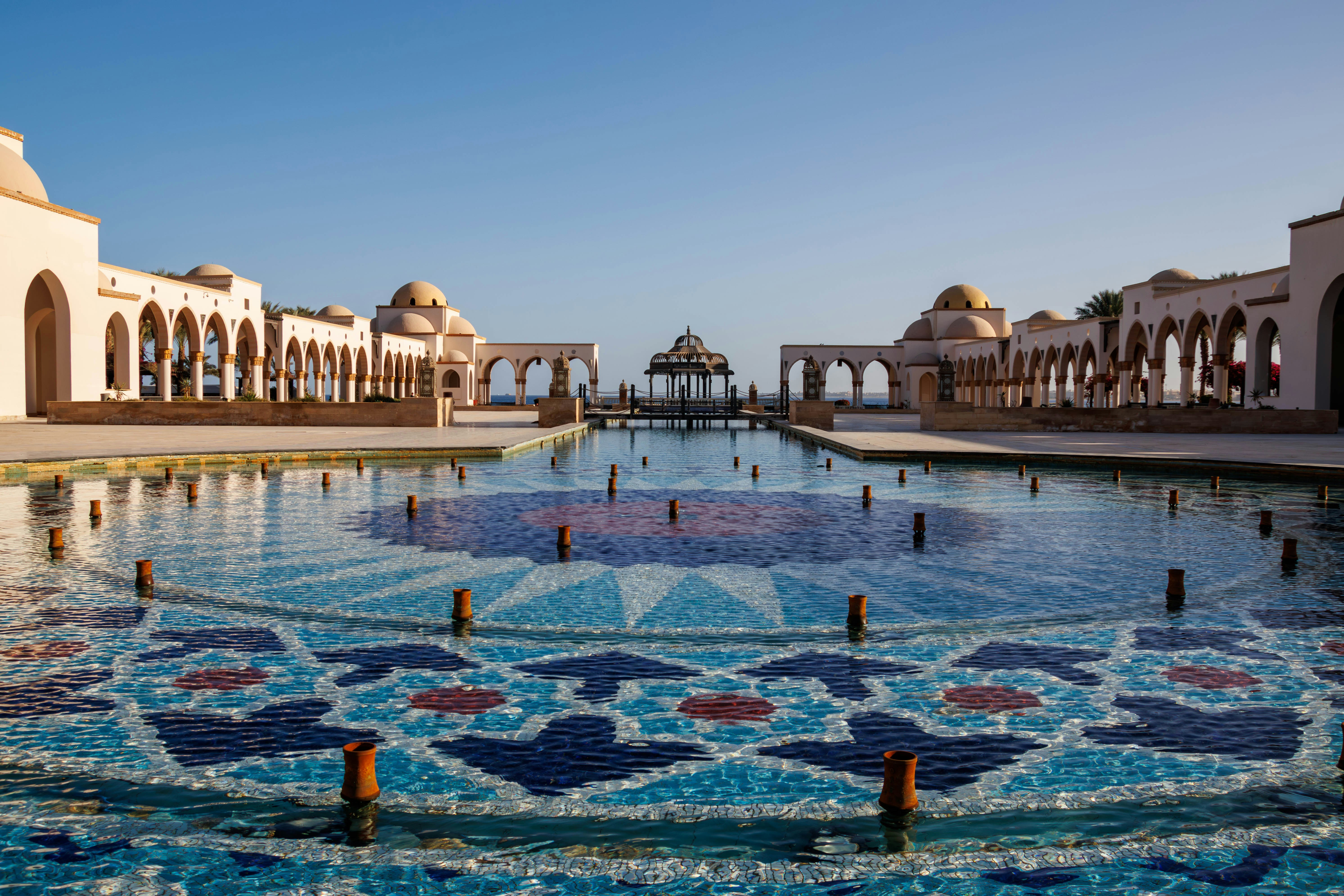 Ornate fountain with patterned tiles and arched colonnades