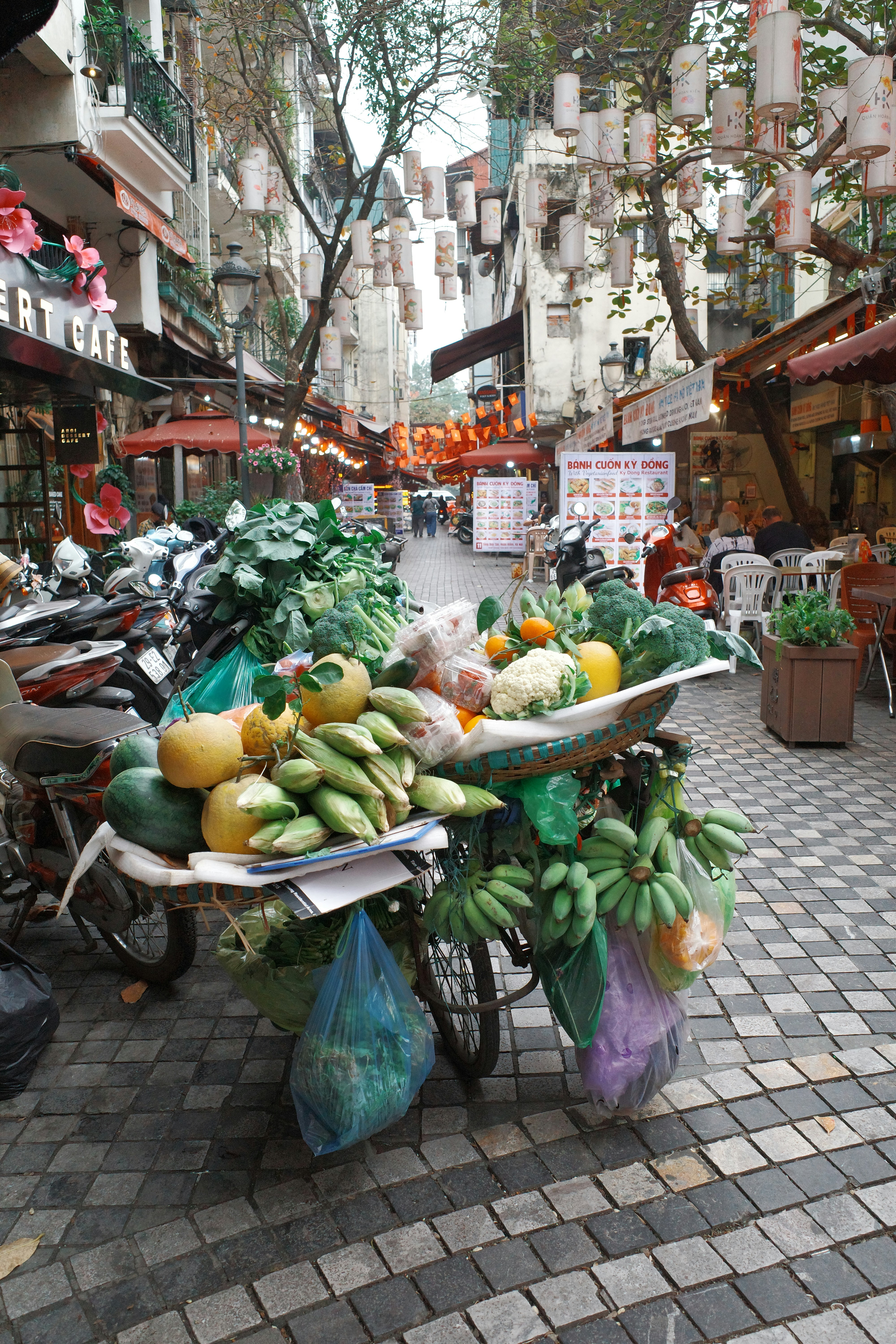 A cart full of fresh produce on a city street.