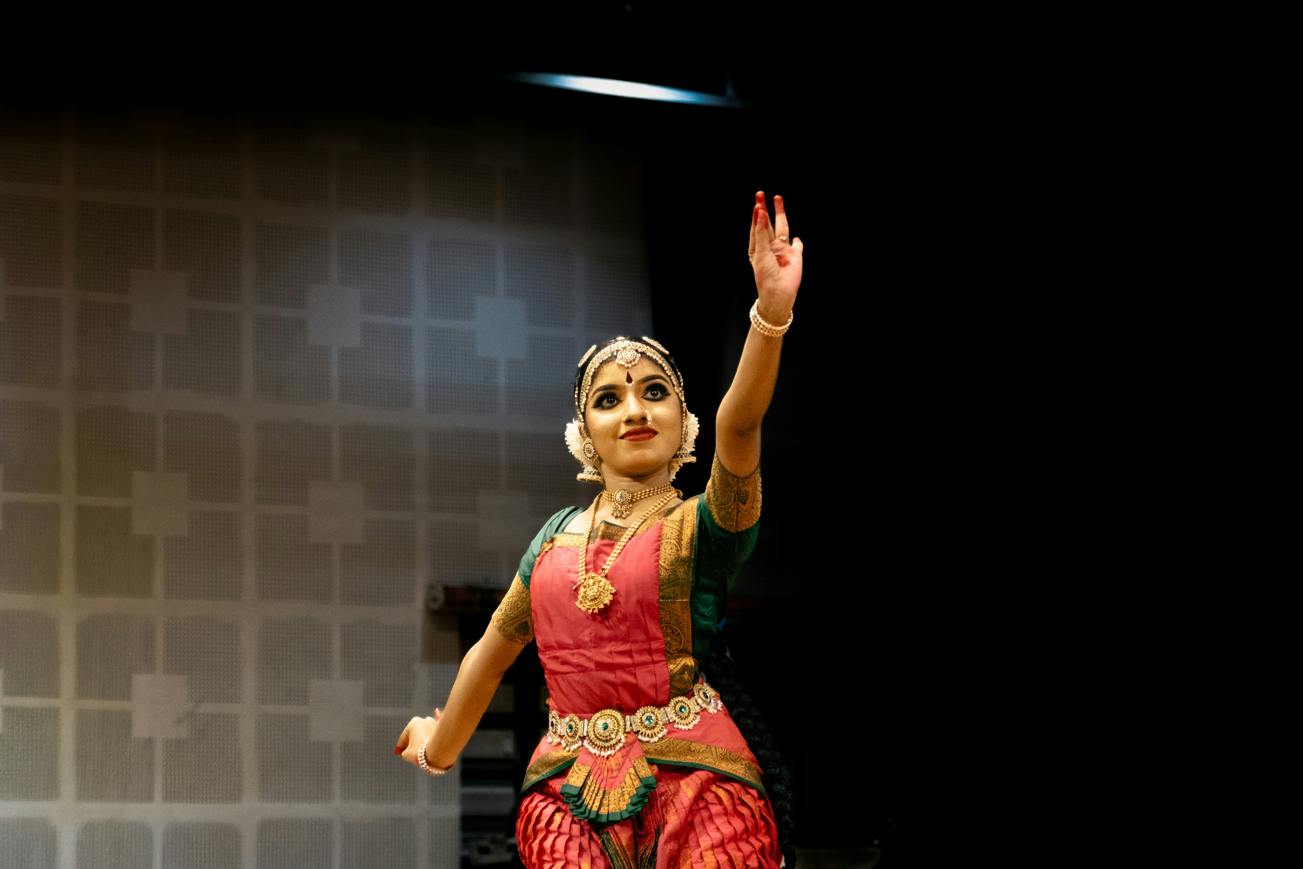 A woman in traditional indian attire performs a dance.