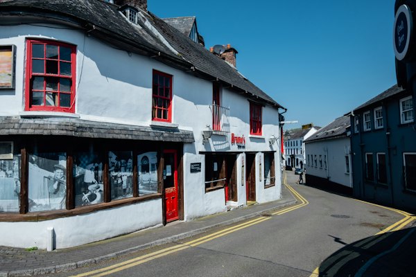 White building with red windows on a street — Cork & Kinsale, Ireland