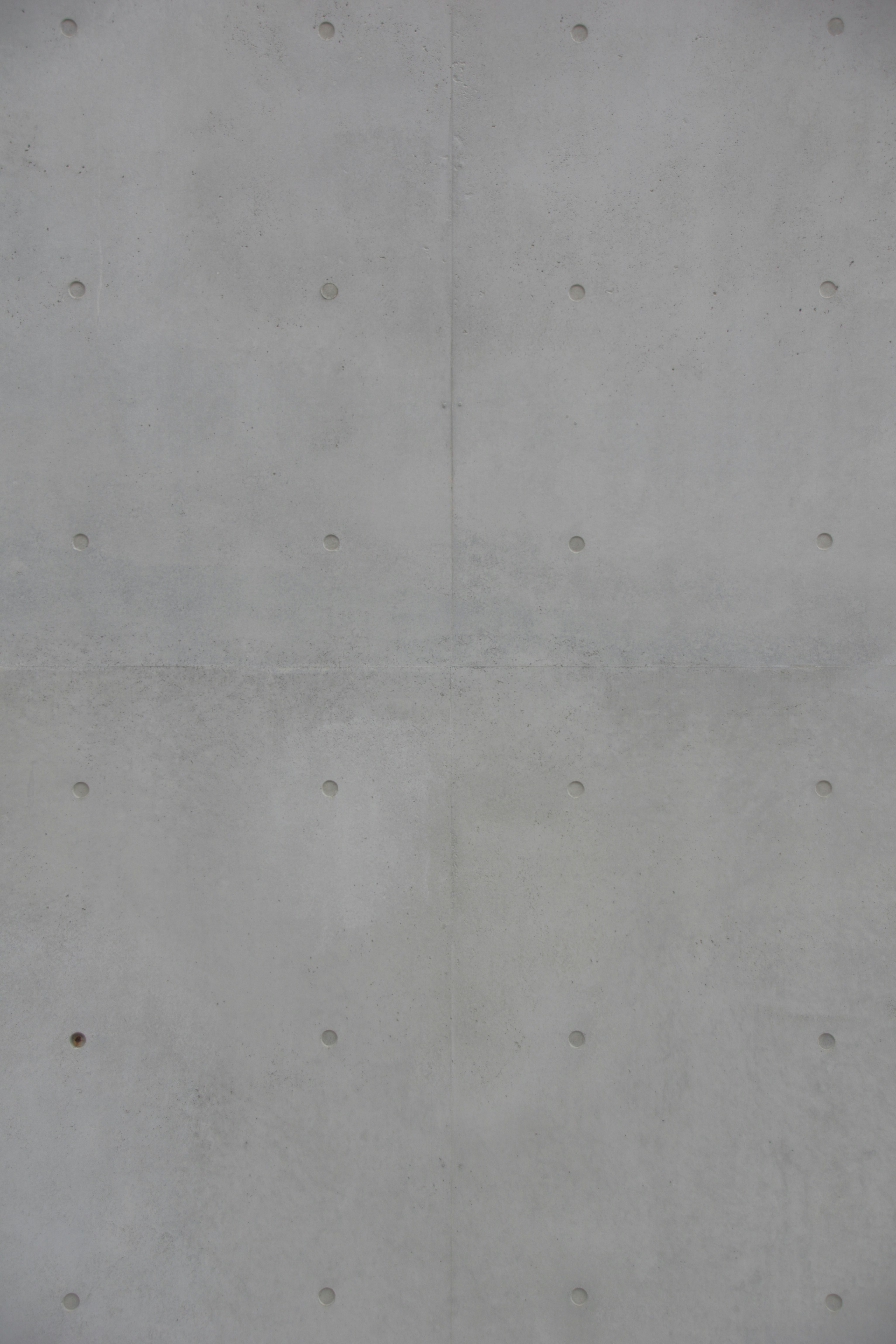 A concrete wall with small circular indentations.