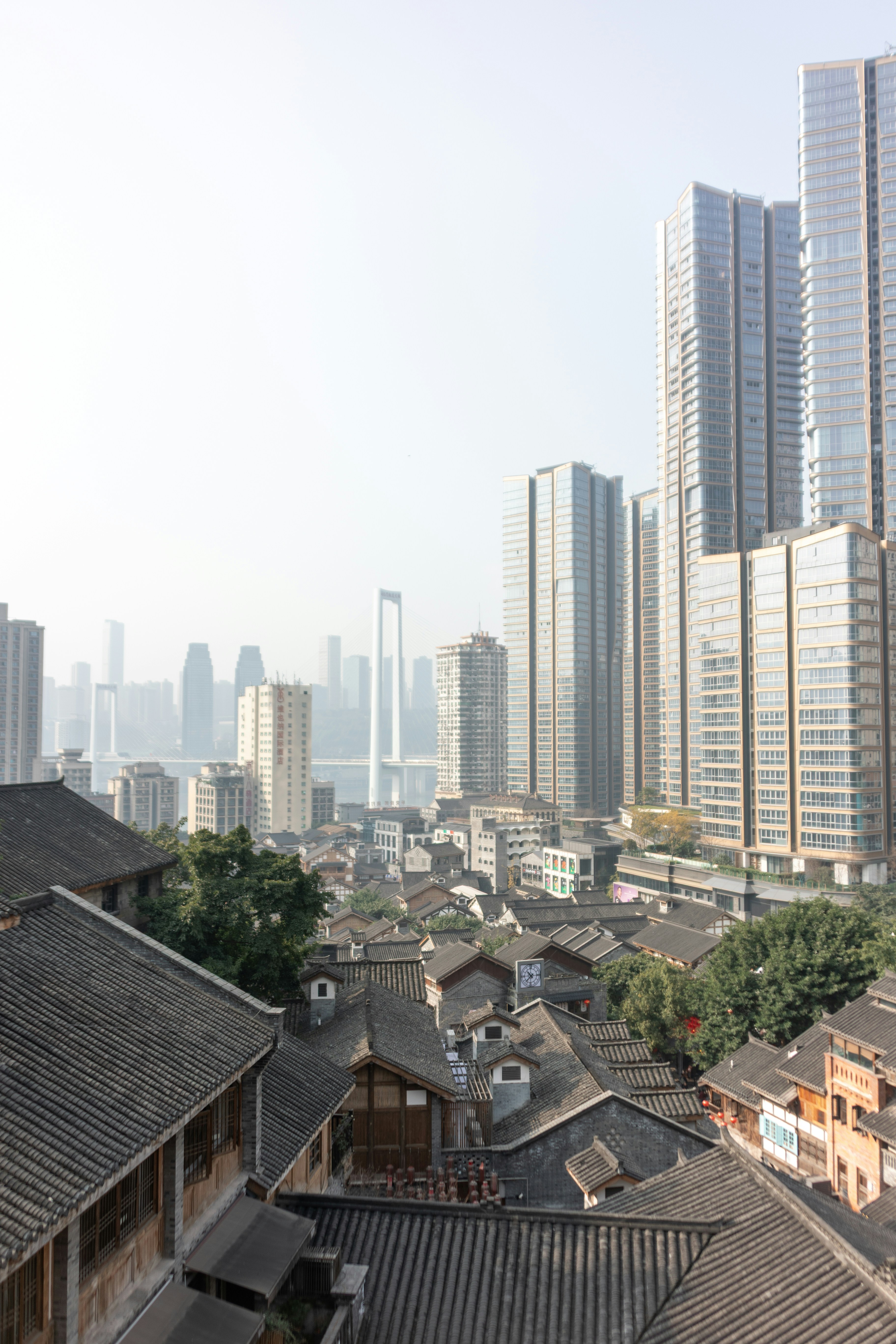 Historic rooftops contrast with modern skyscrapers in a city.