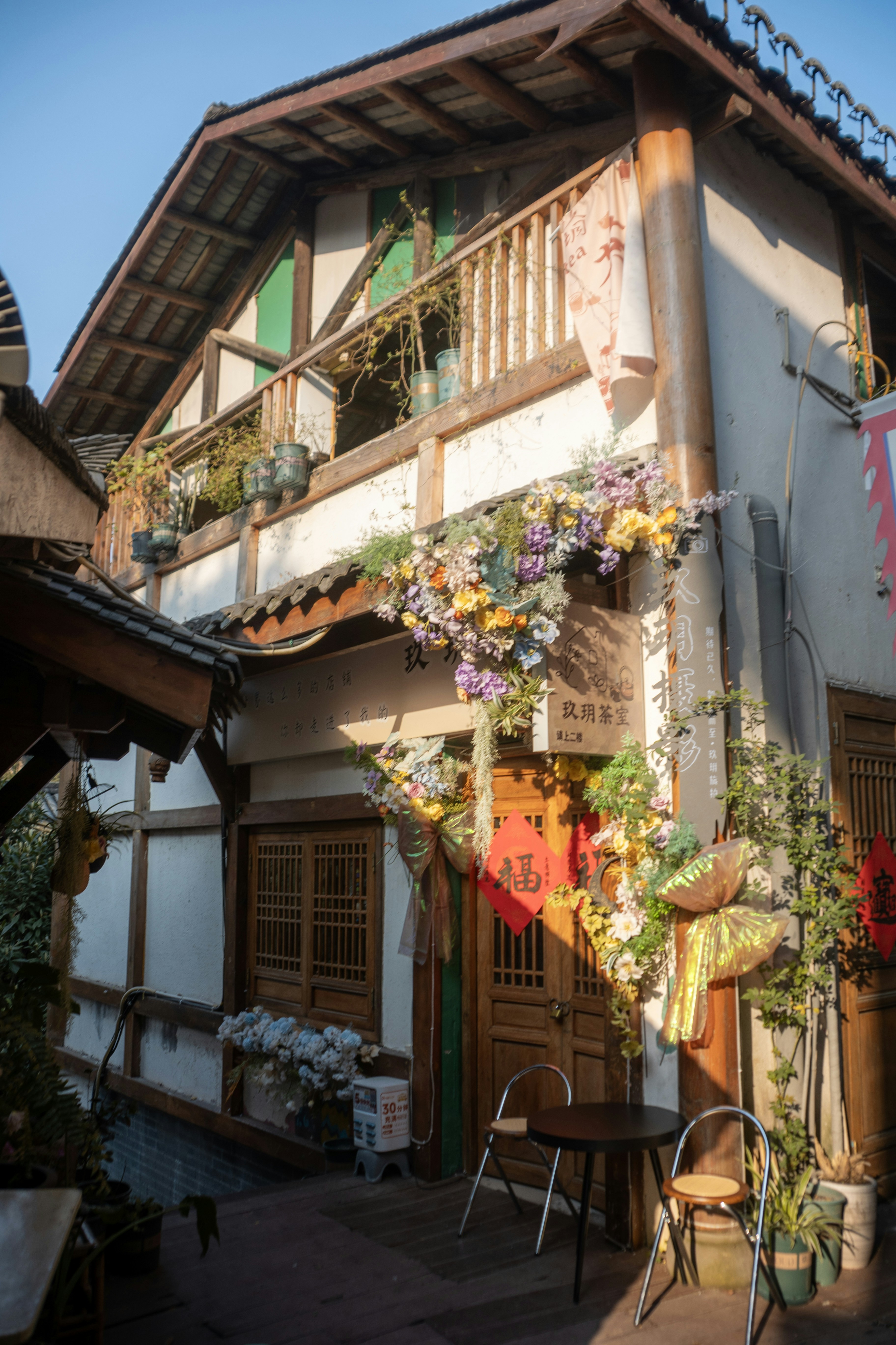 Encantadora fachada de edificio adornada con flores coloridas y vegetación.