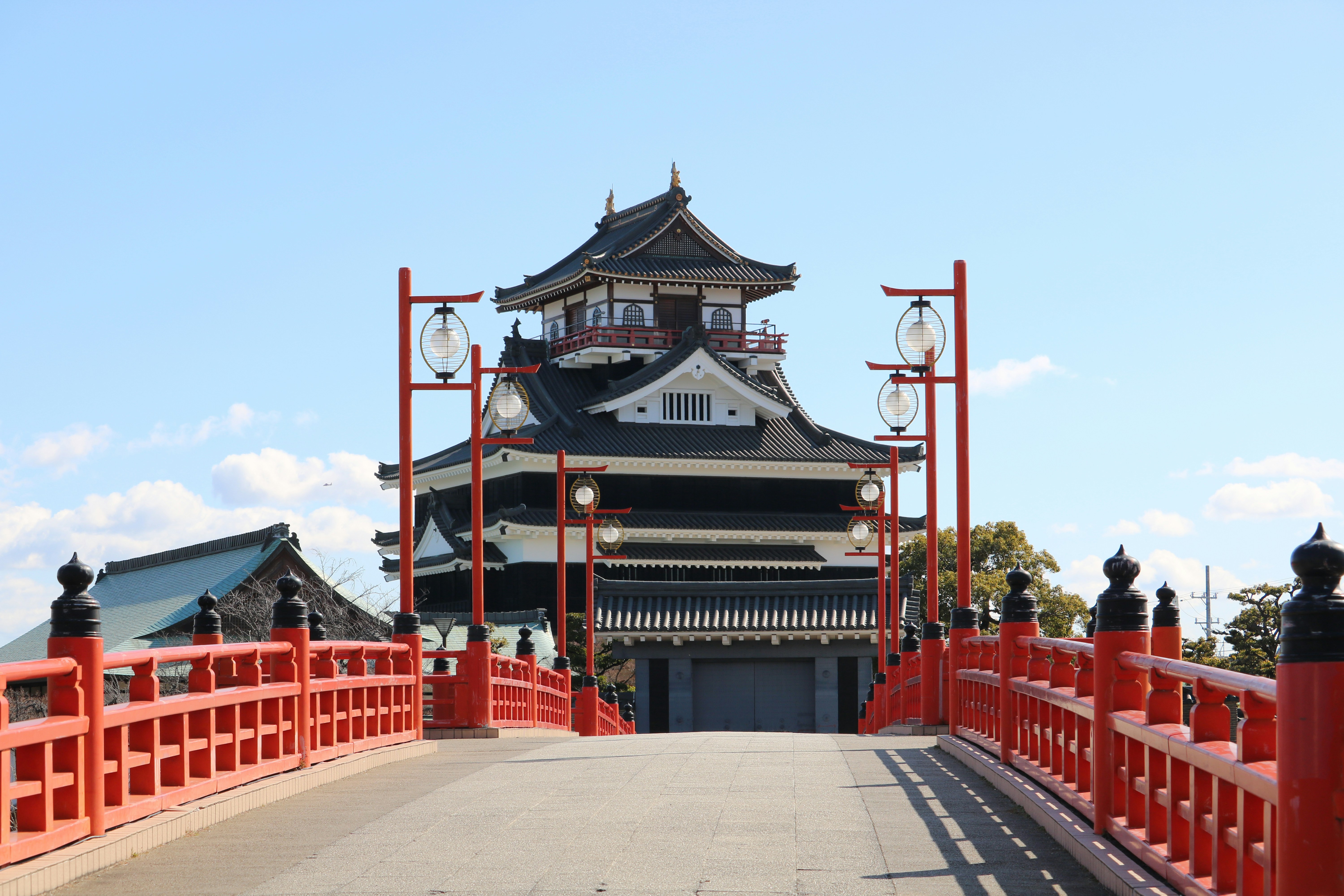 A traditional japanese castle with a red bridge