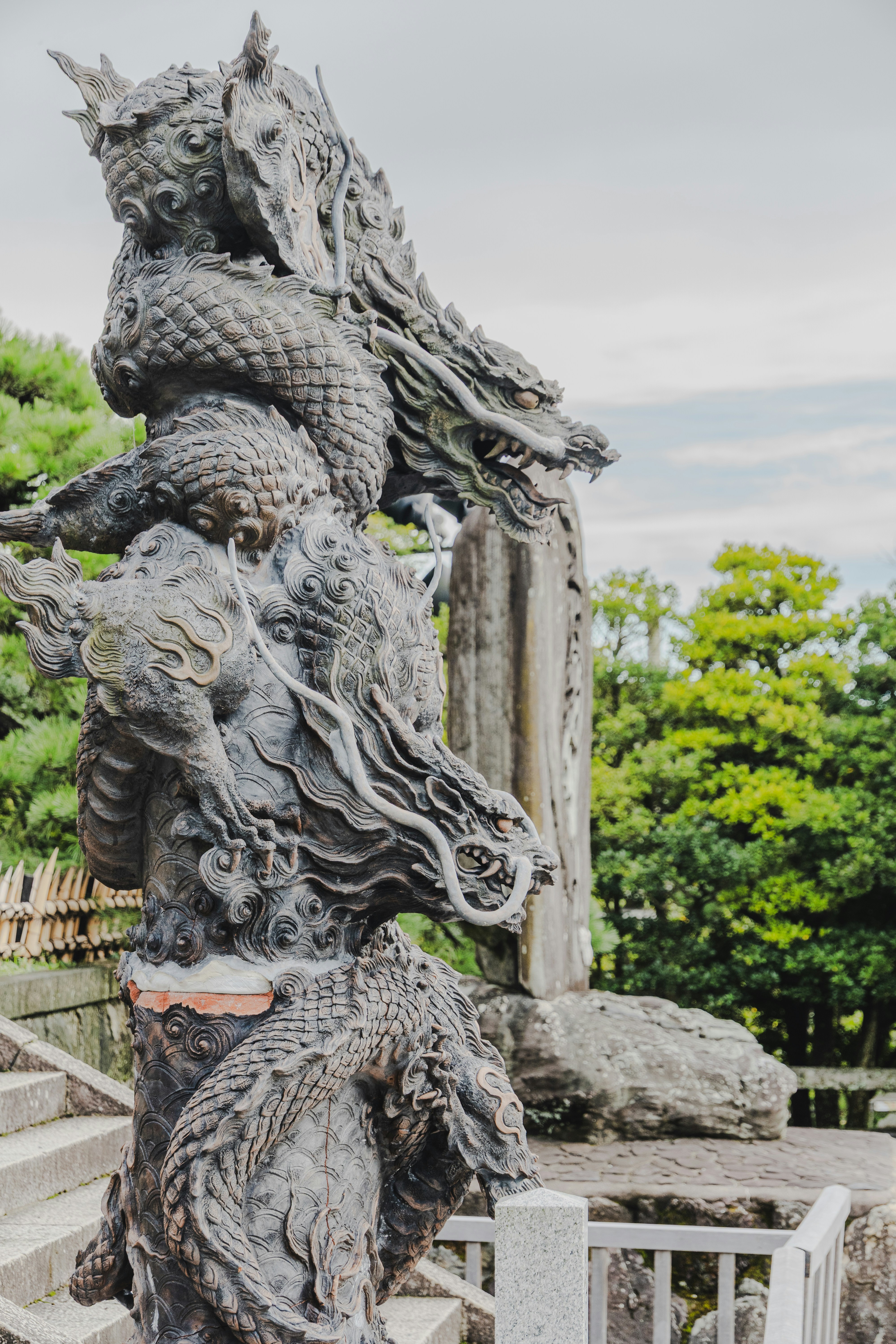 Stone dragon statue with lush greenery in background