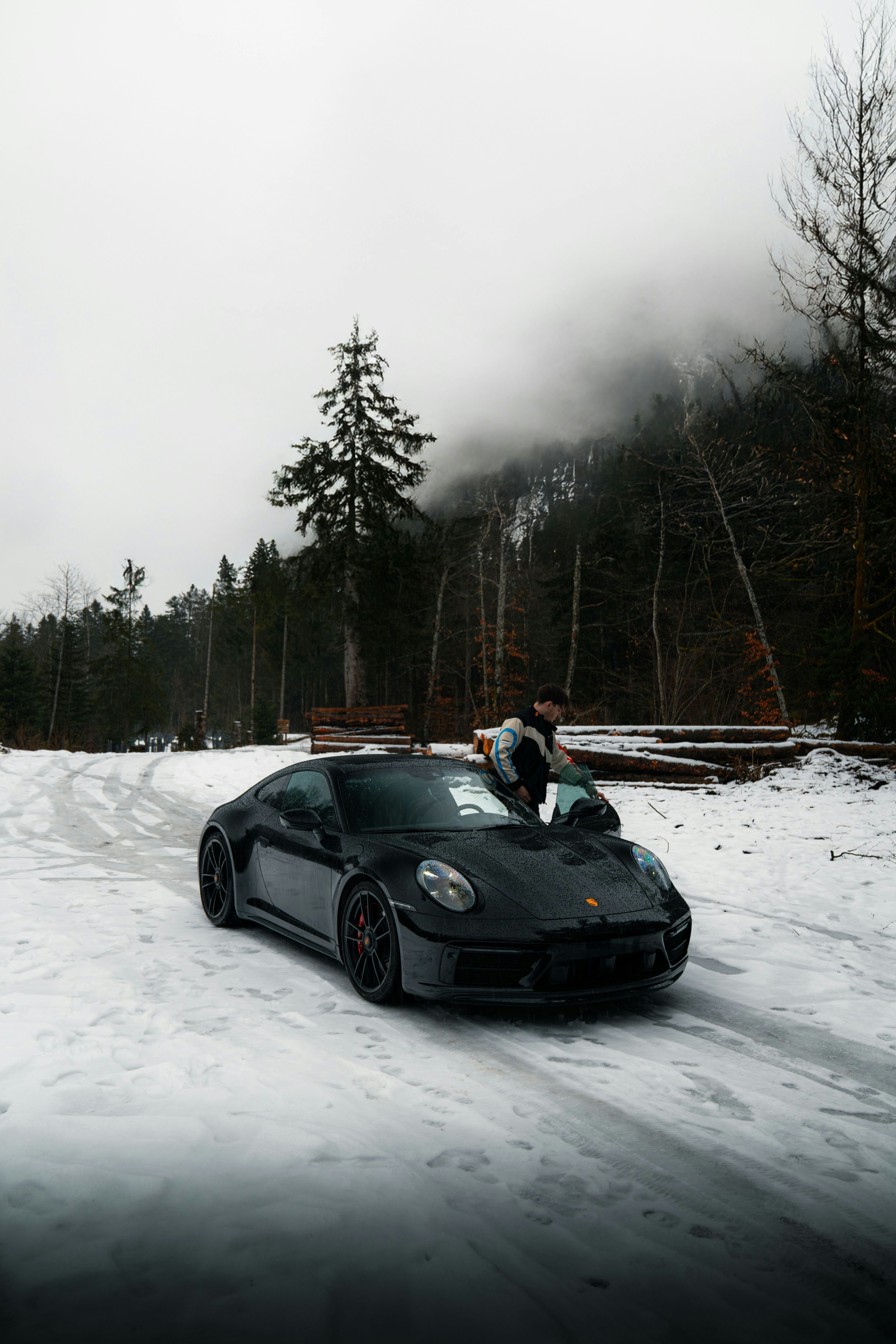 A black sports car parked on a snowy road.