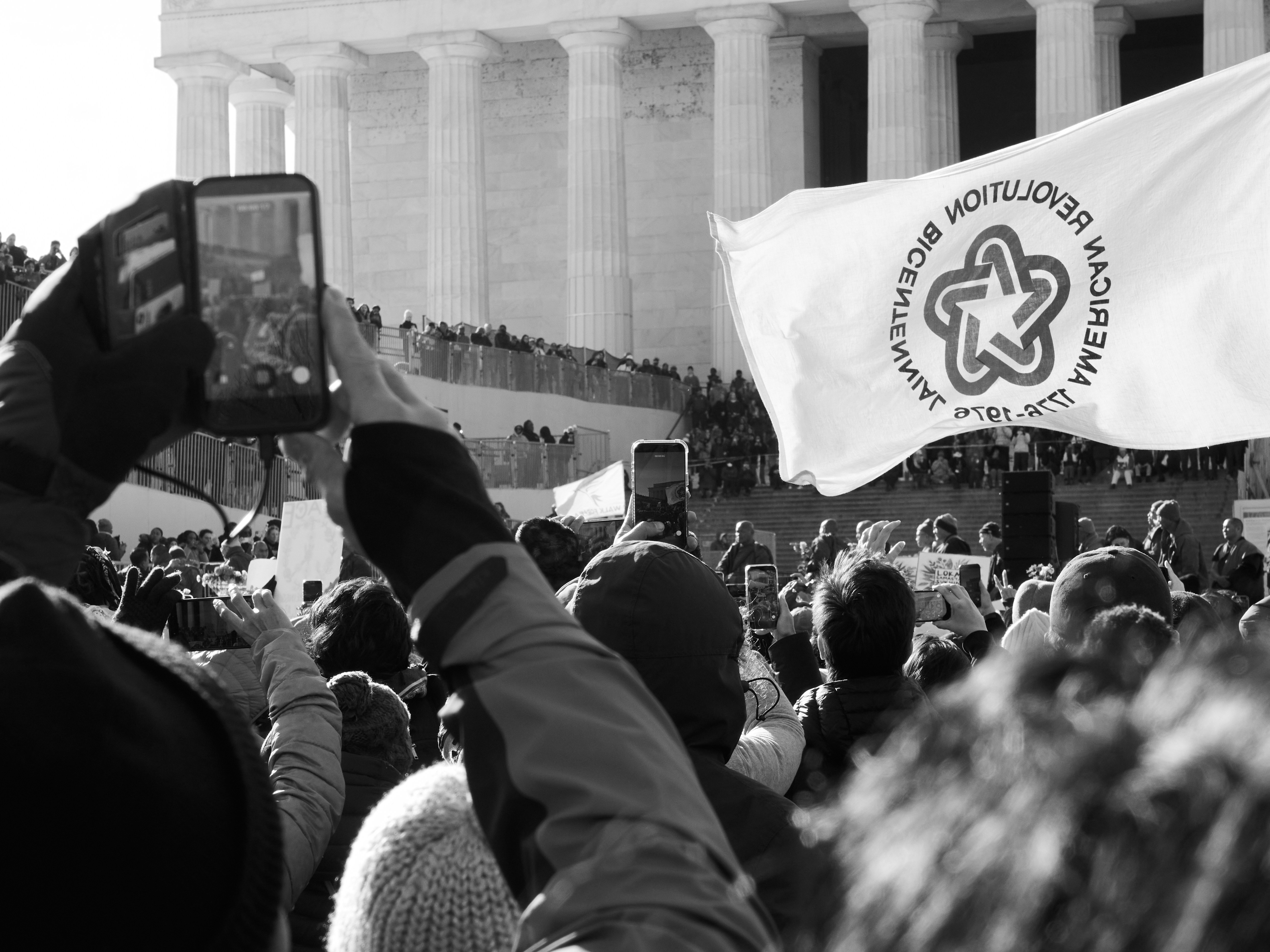 Crowd gathered at a monument with a flag.