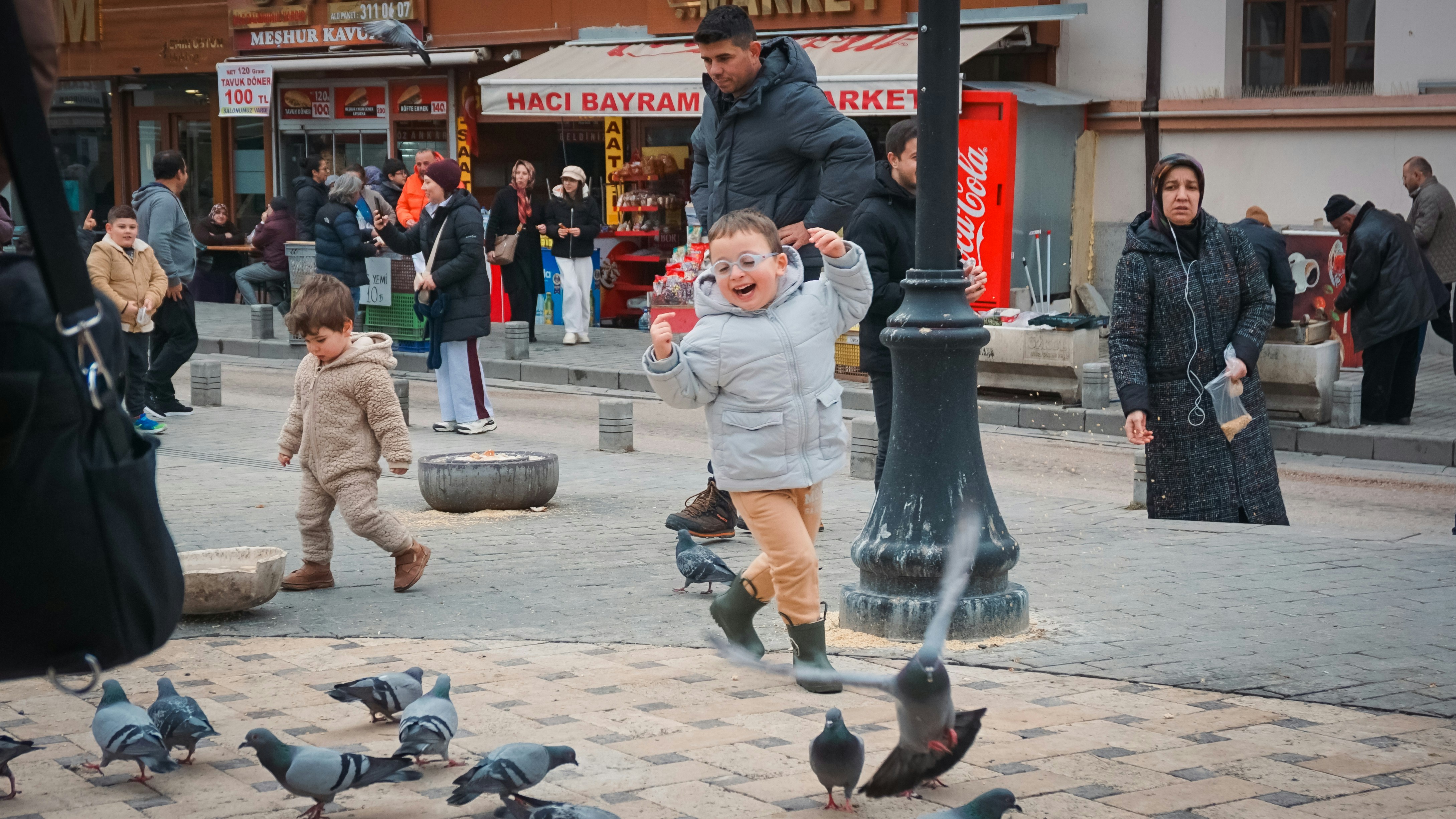 children play around in a busy town square in Turkey