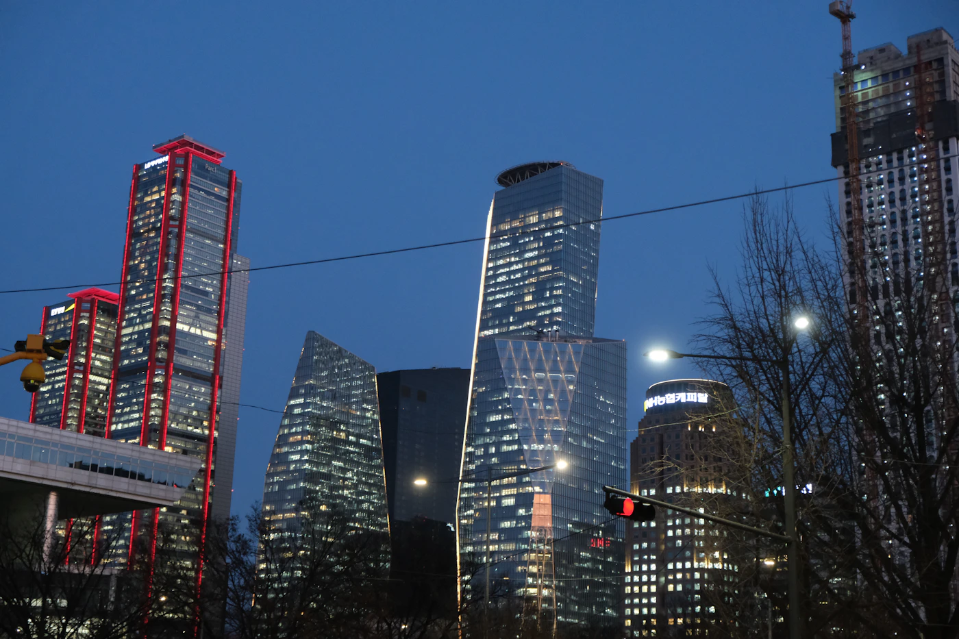 Glass office towers lit at dusk behind a traffic light