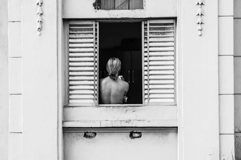 Woman with her back to an open window, indicating you dont have to be available to everyone all the 