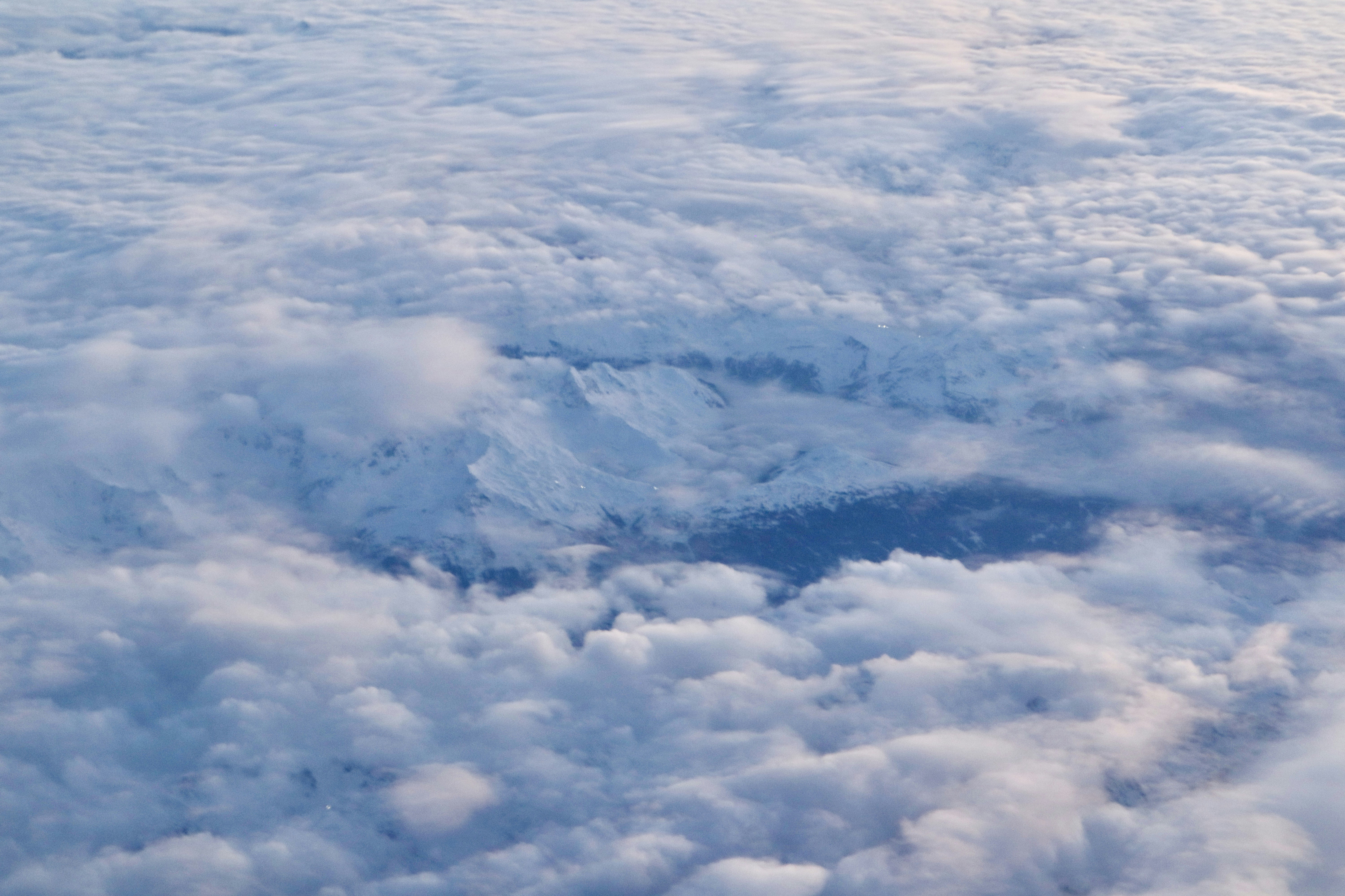 Fluffy white clouds with mountains visible below