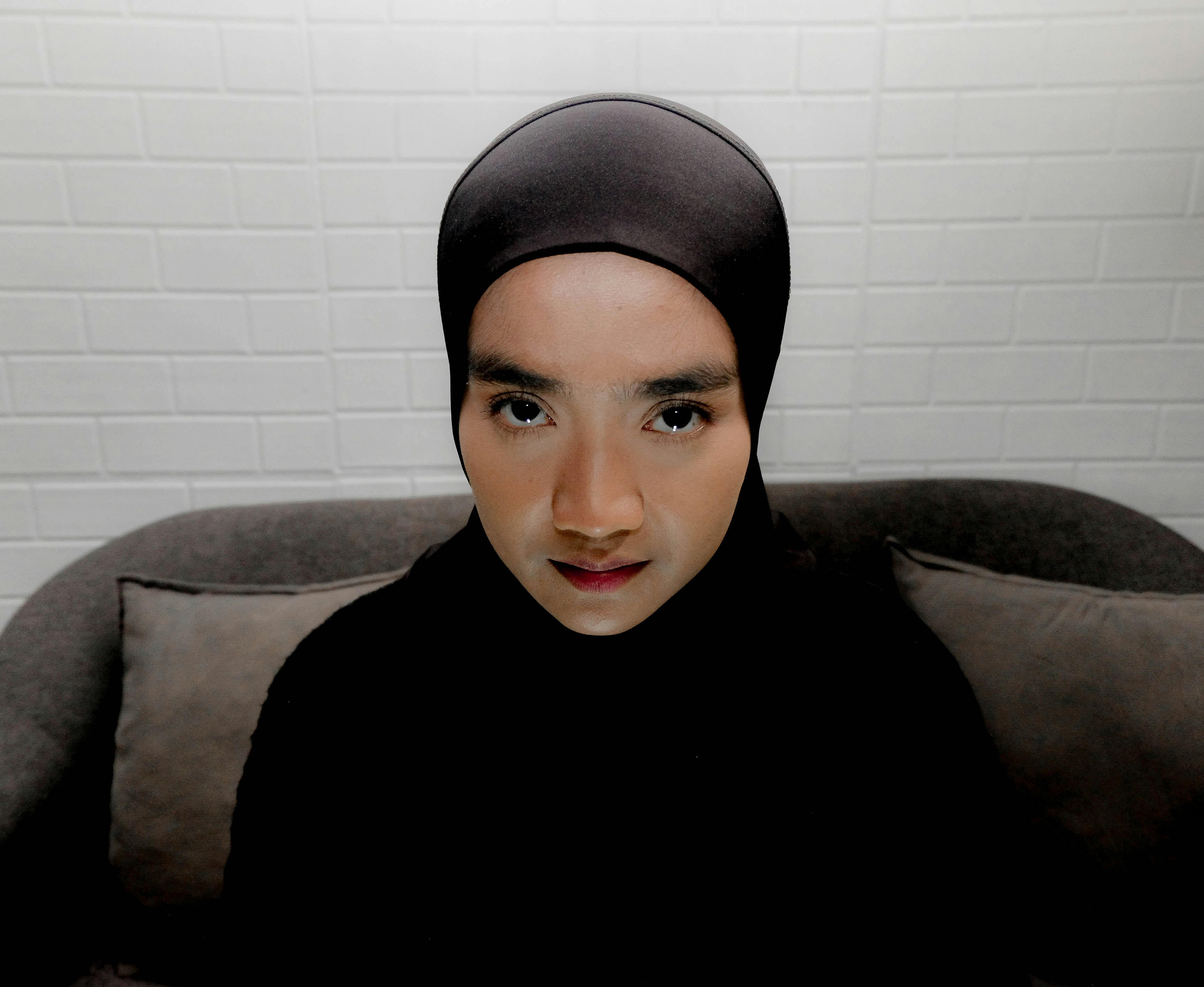 Une personne portant un hijab noir et un foulard.