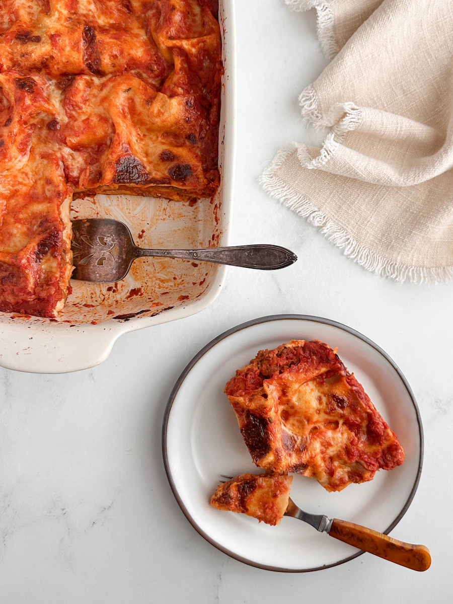 A slice of lasagne served from a baking dish