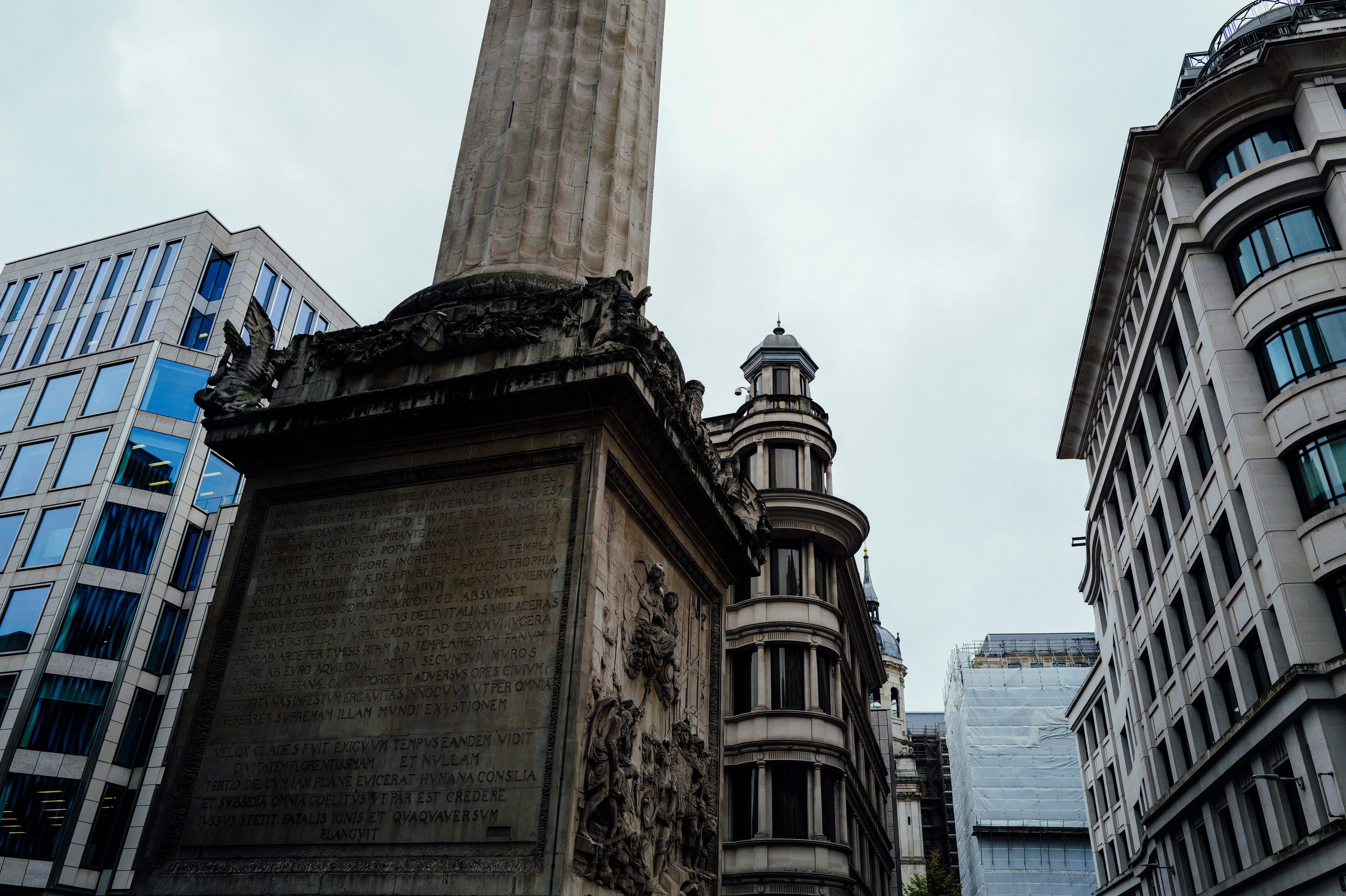 Monument surrounded by modern city buildings