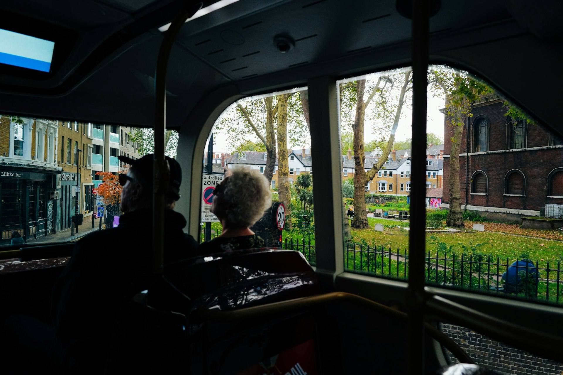 View from a tram window of a park and buildings