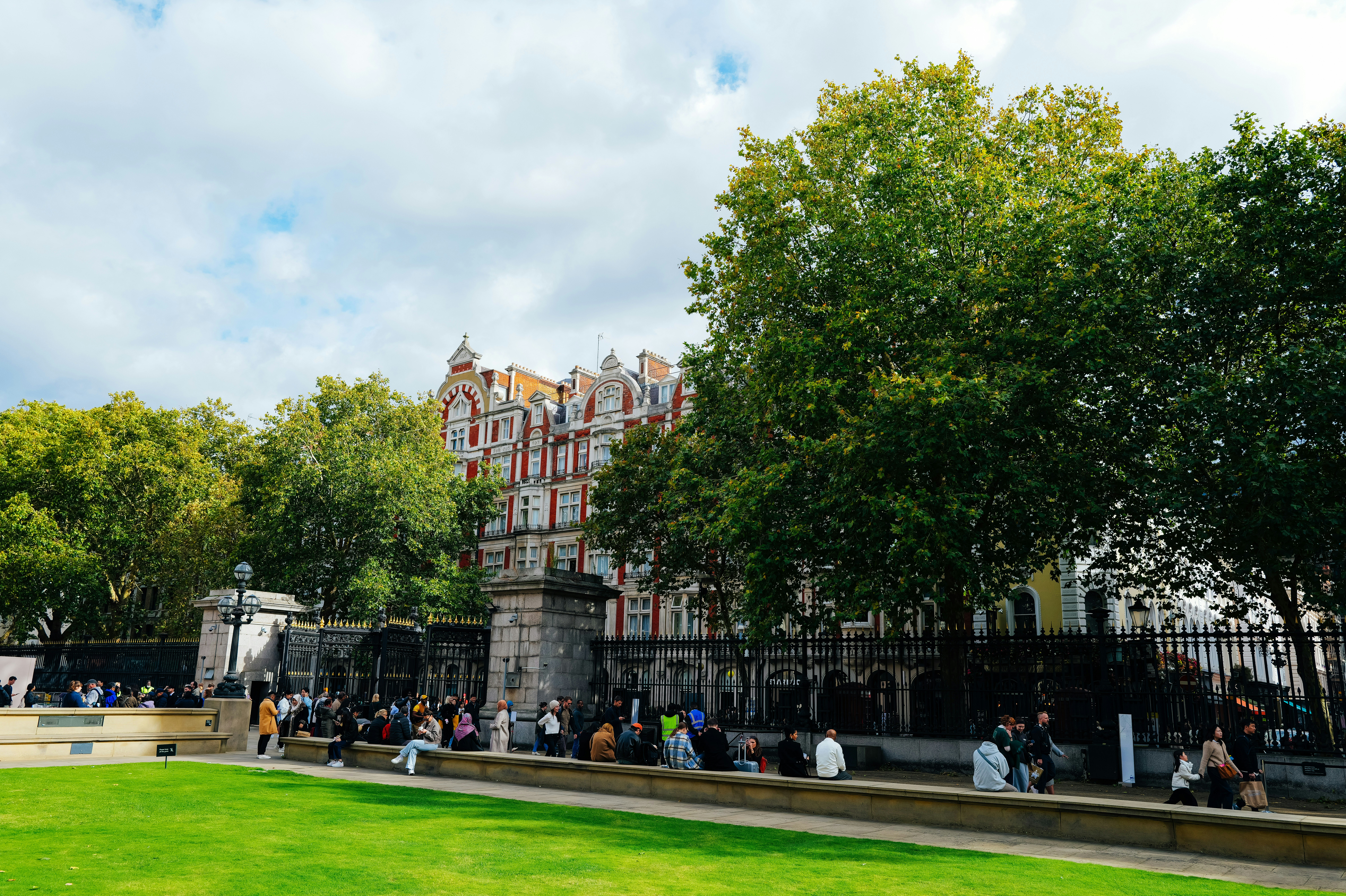 사람들은 역사적인 건물 근처에서 햇살 가득한 날 휴식을 취합니다.
