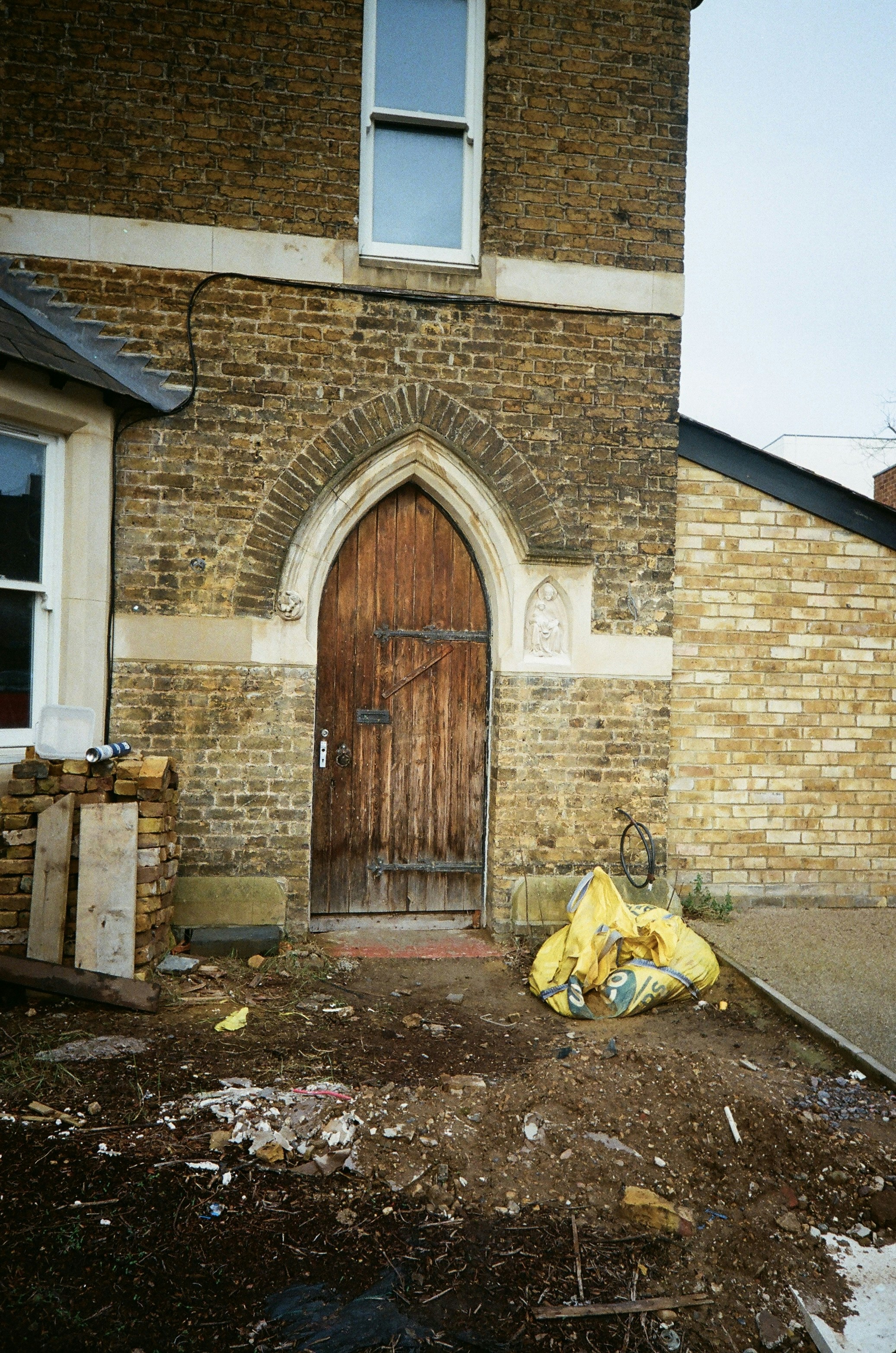 Old wooden door on a brick building with debris.