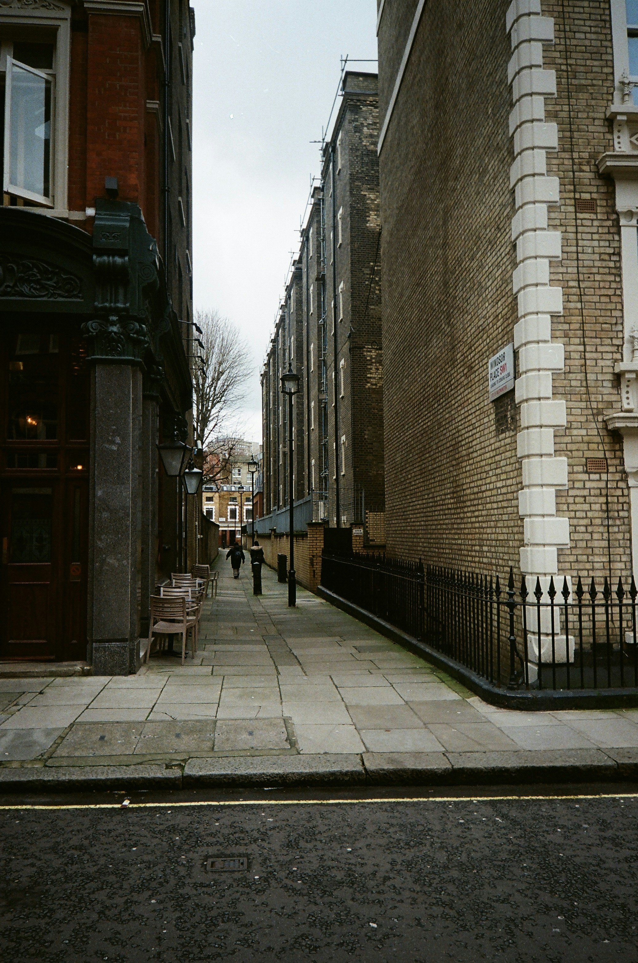 A person walks down a narrow london street.