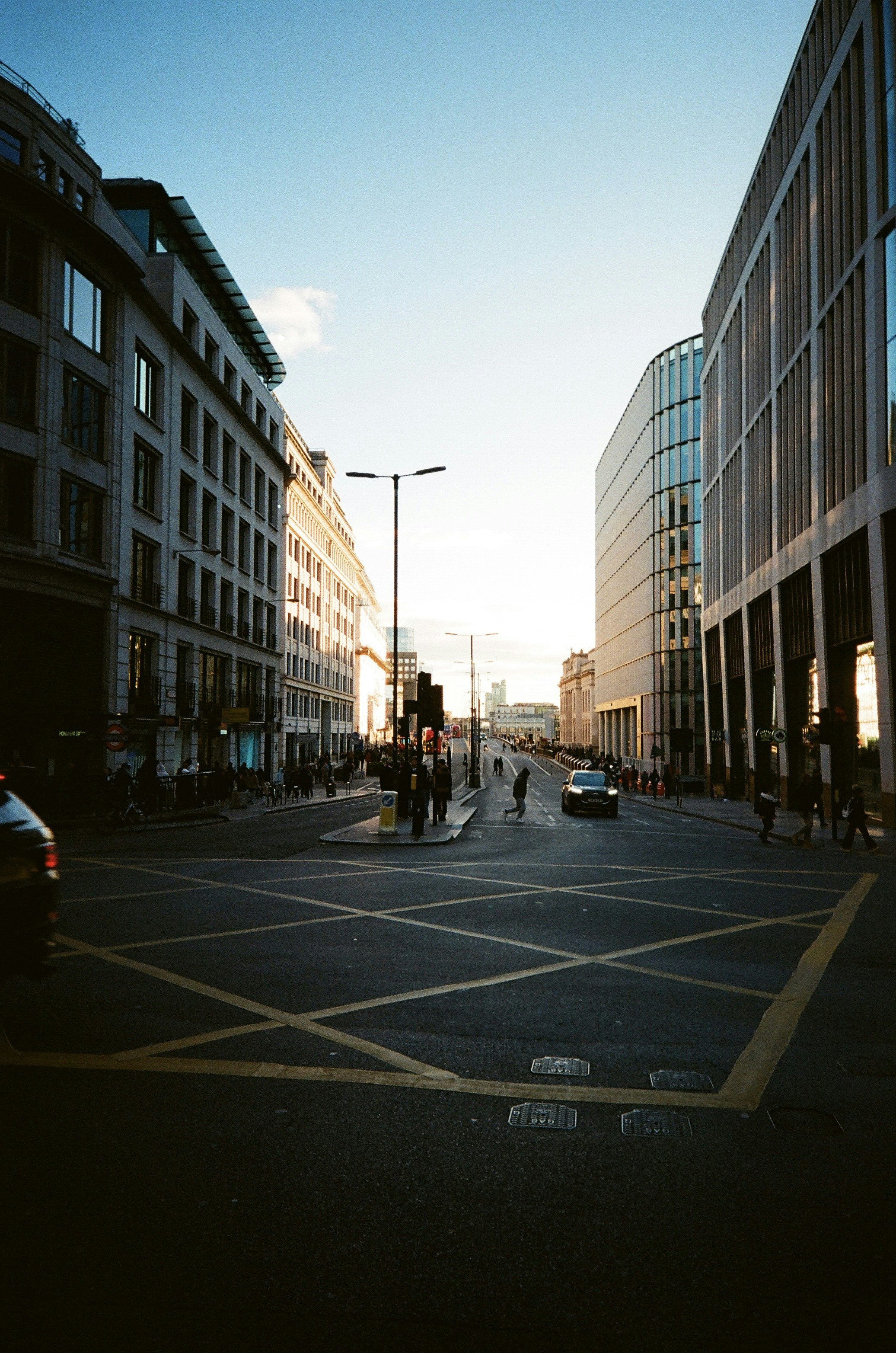 City street with modern buildings and cars at sunset