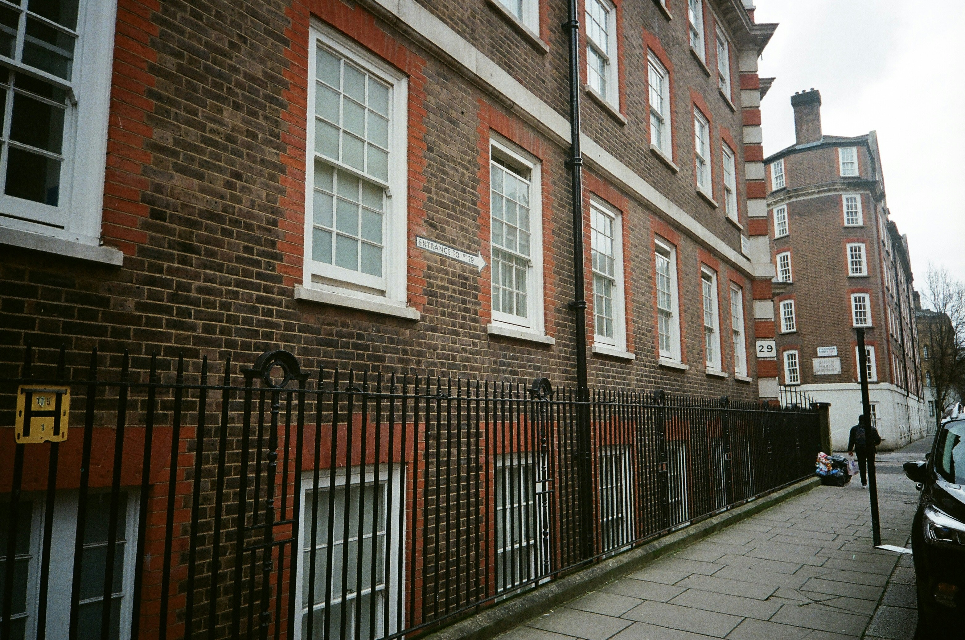 Brick building with white windows and a sidewalk