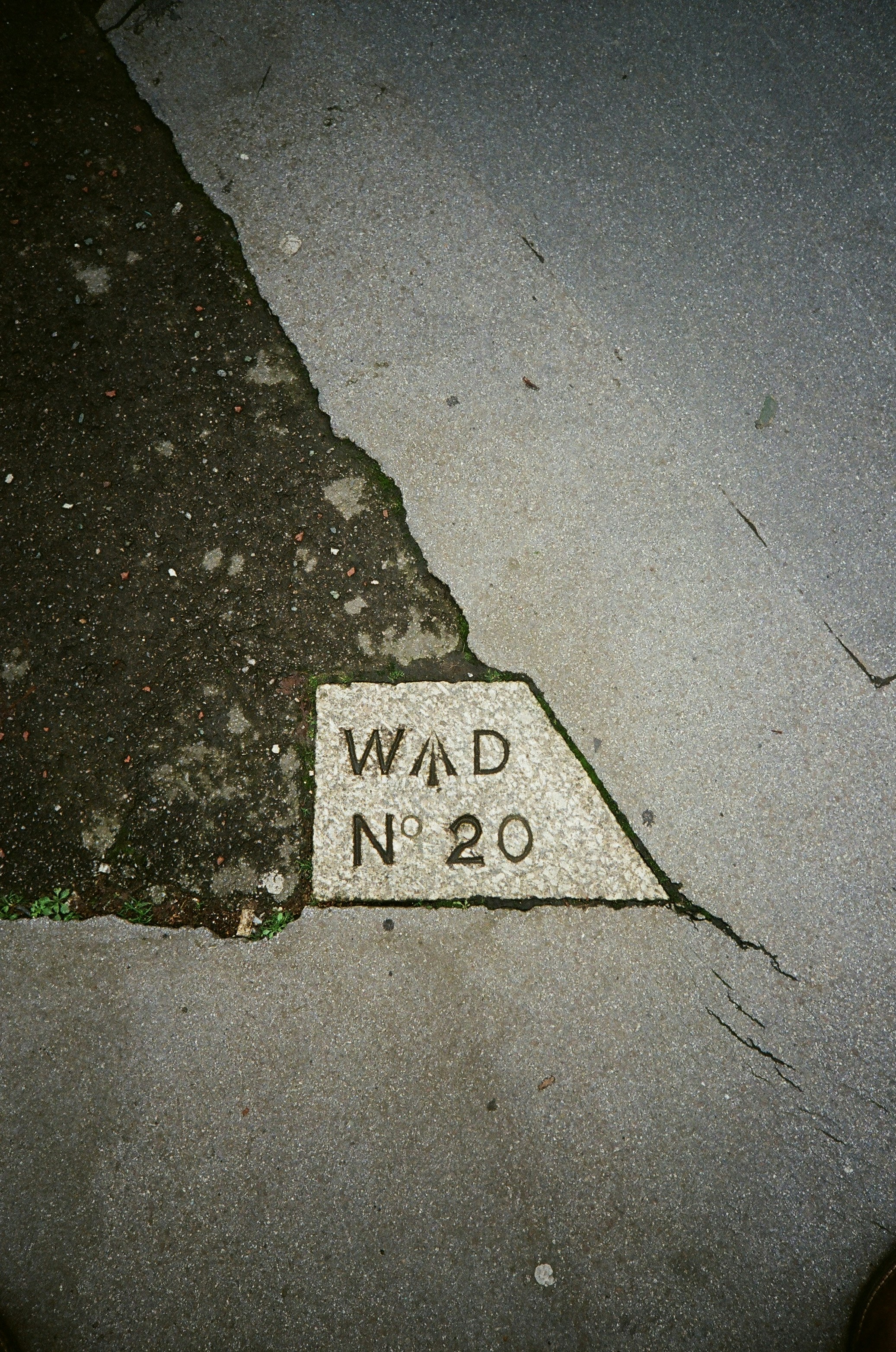 Stone marker with wad n 20 inscription on pavement