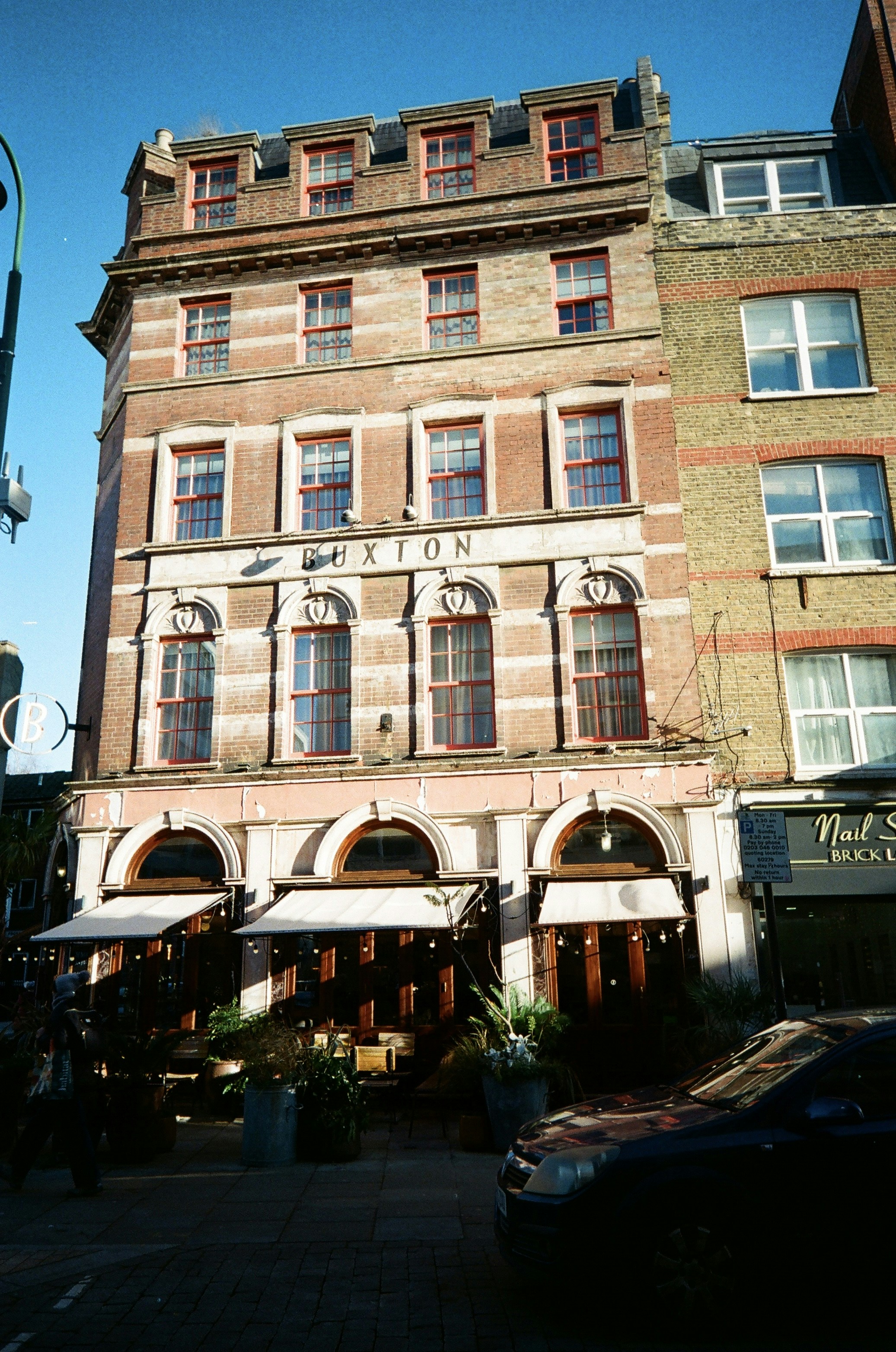 Red brick building with arched entrances and windows.