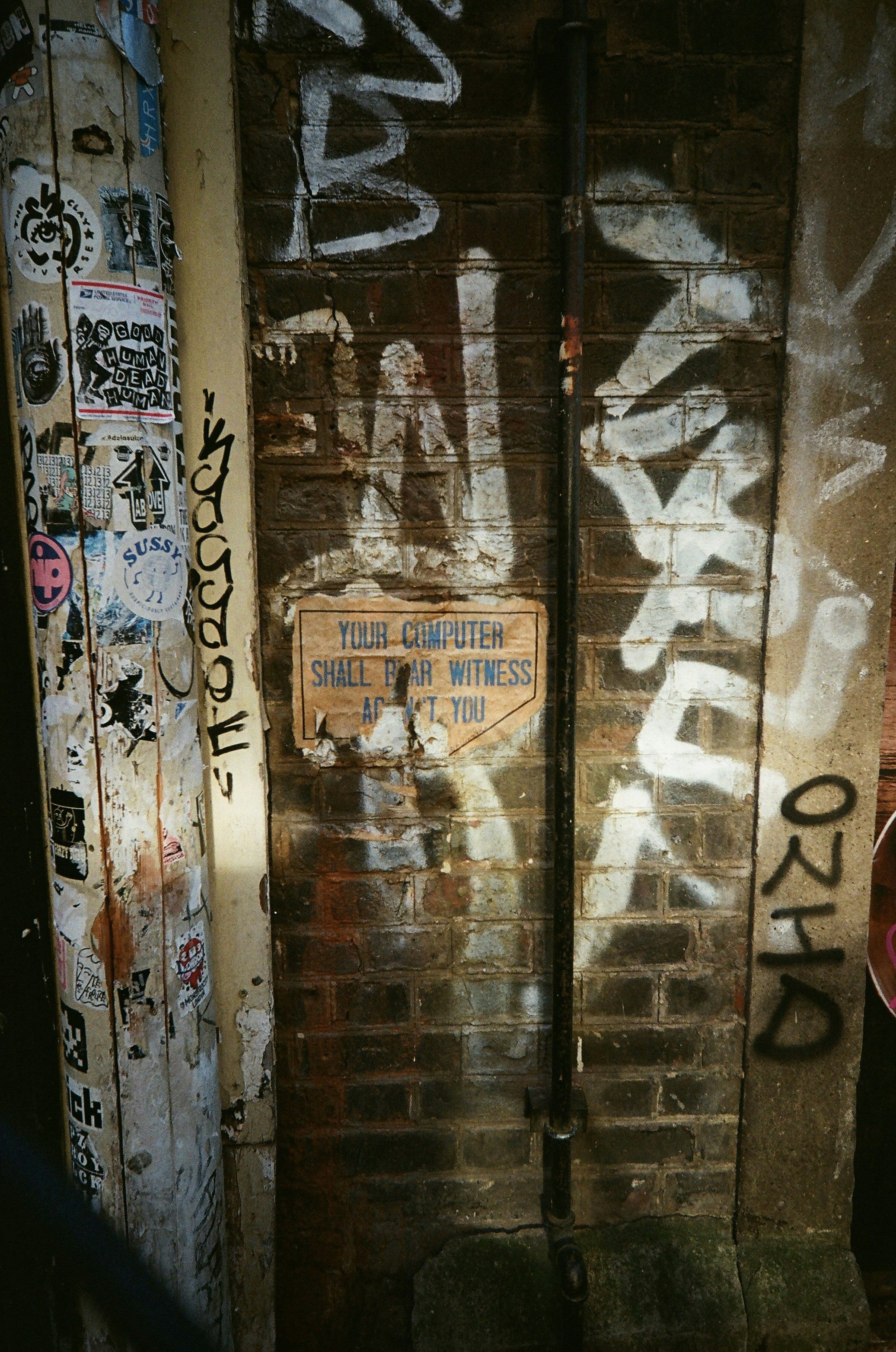 Graffiti covers a brick wall with a sign