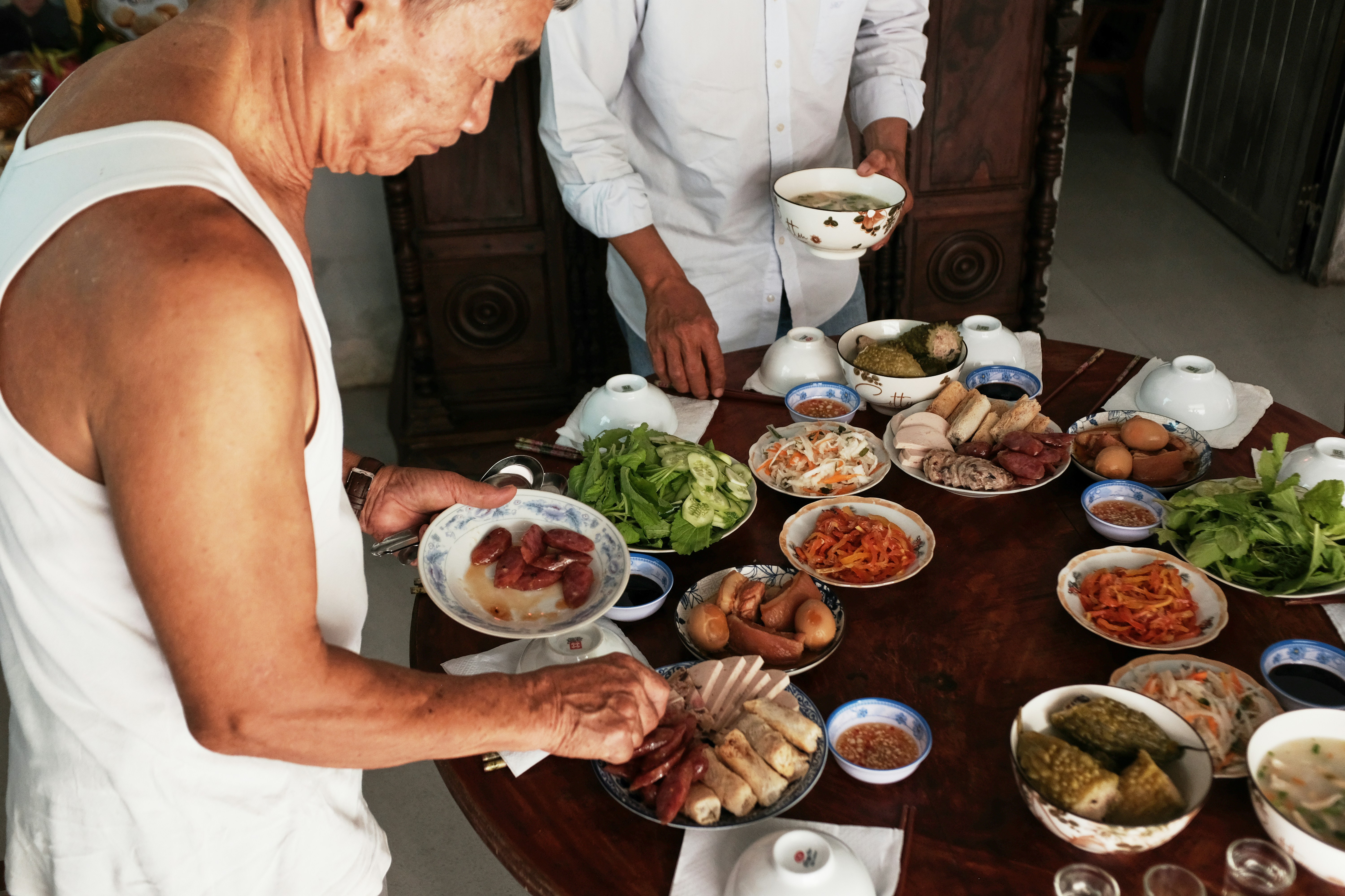 Two people preparing a large meal on a table.