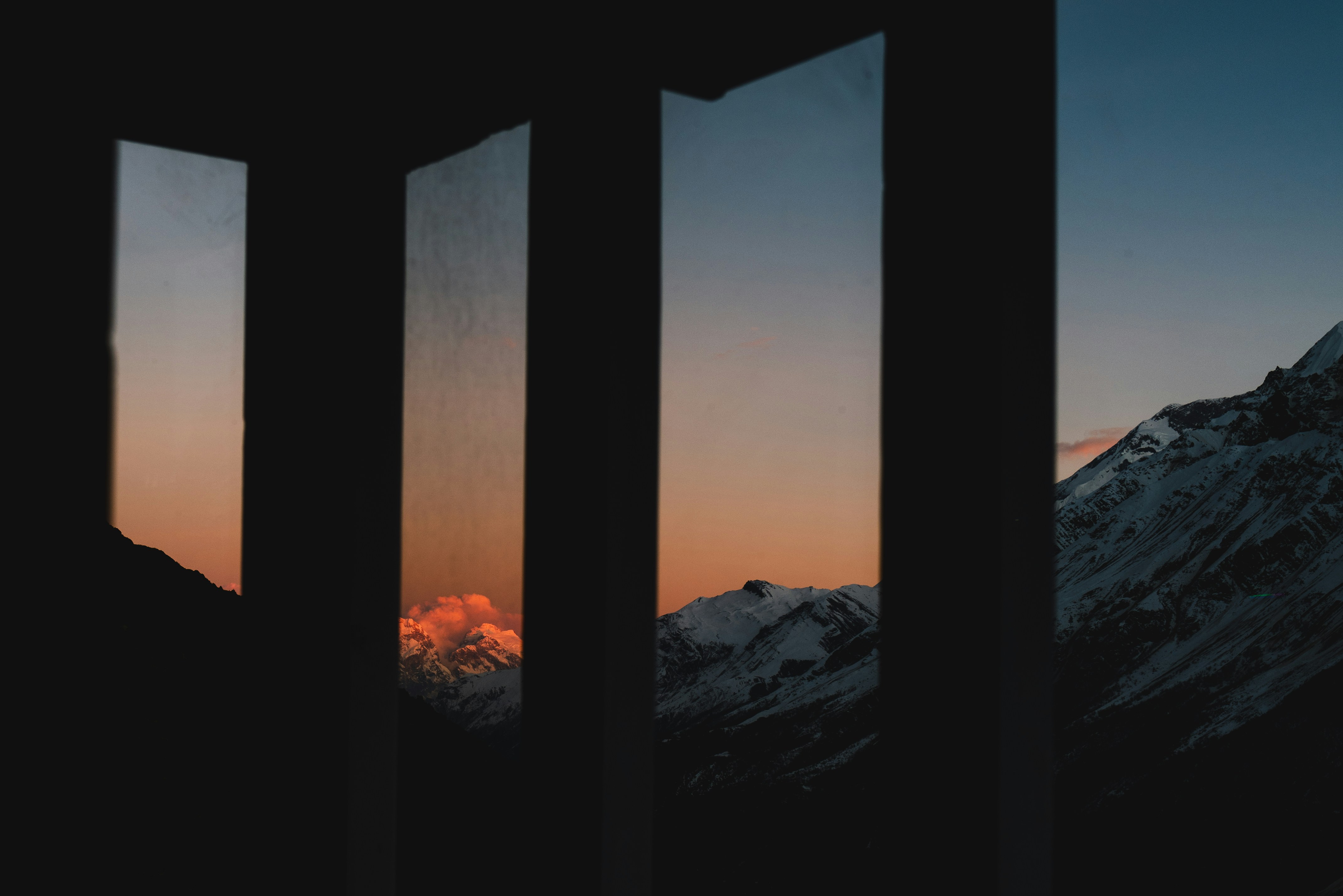 Mountain landscape viewed through dark vertical frames.